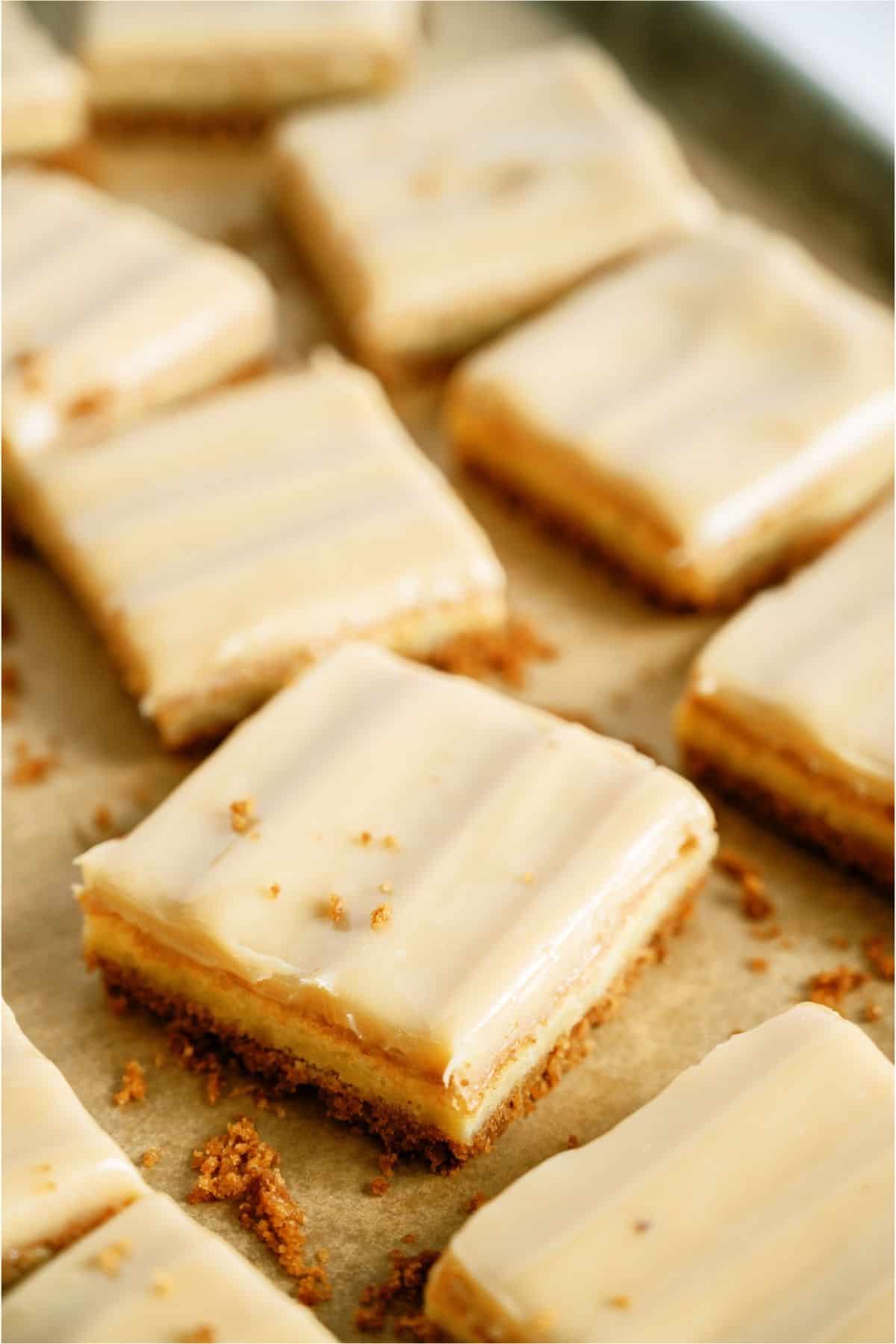 Caramel Cheesecake Bars on a pan cut into squares.