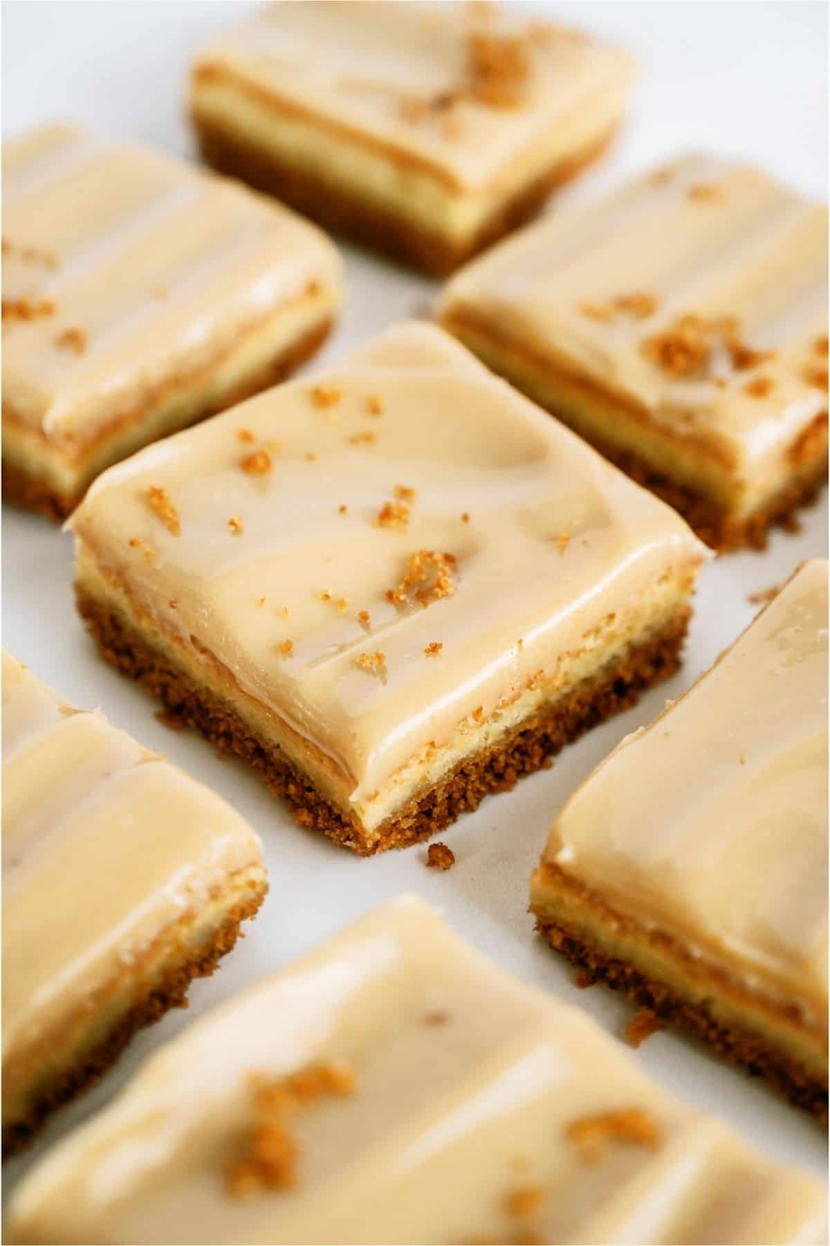 Caramel Cheesecake Bars cut into squares on a white background.