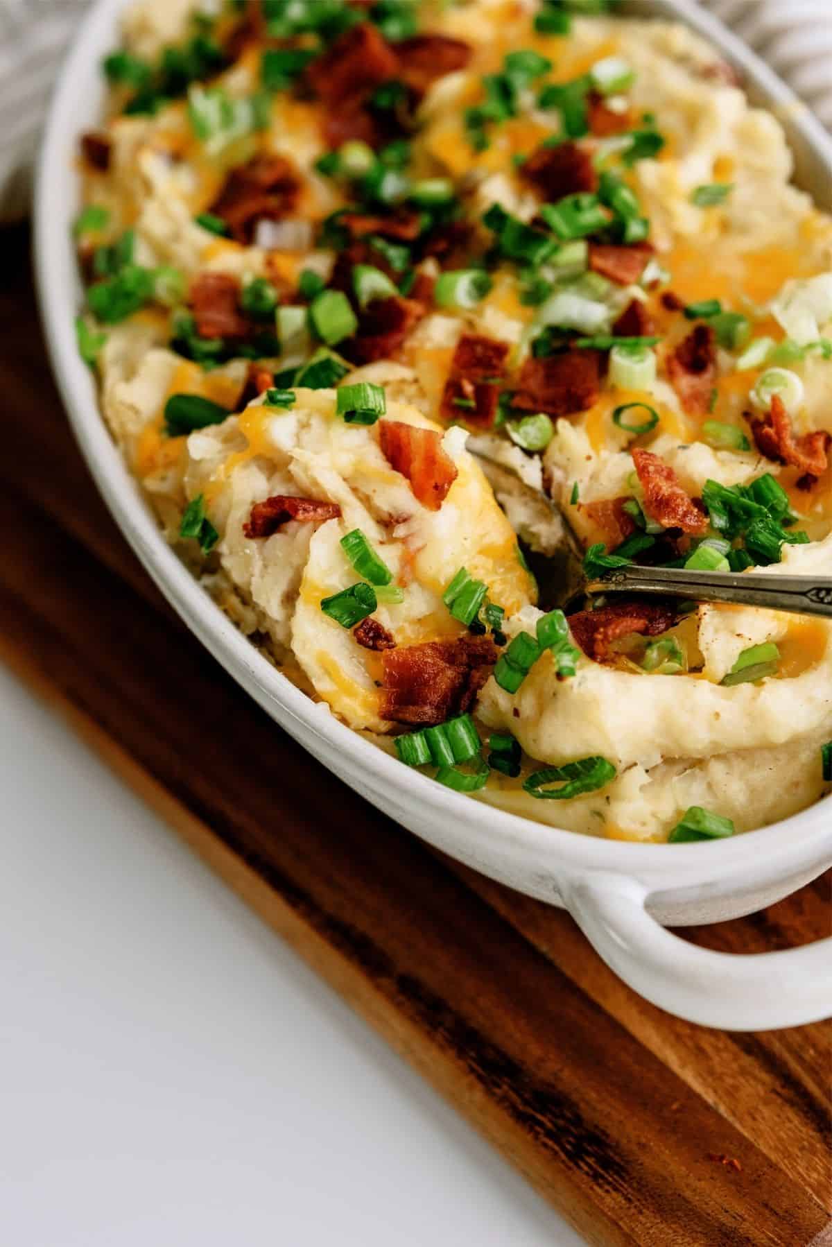 Cheesy Ranch Potatoes in a baking dish with a serving spoon