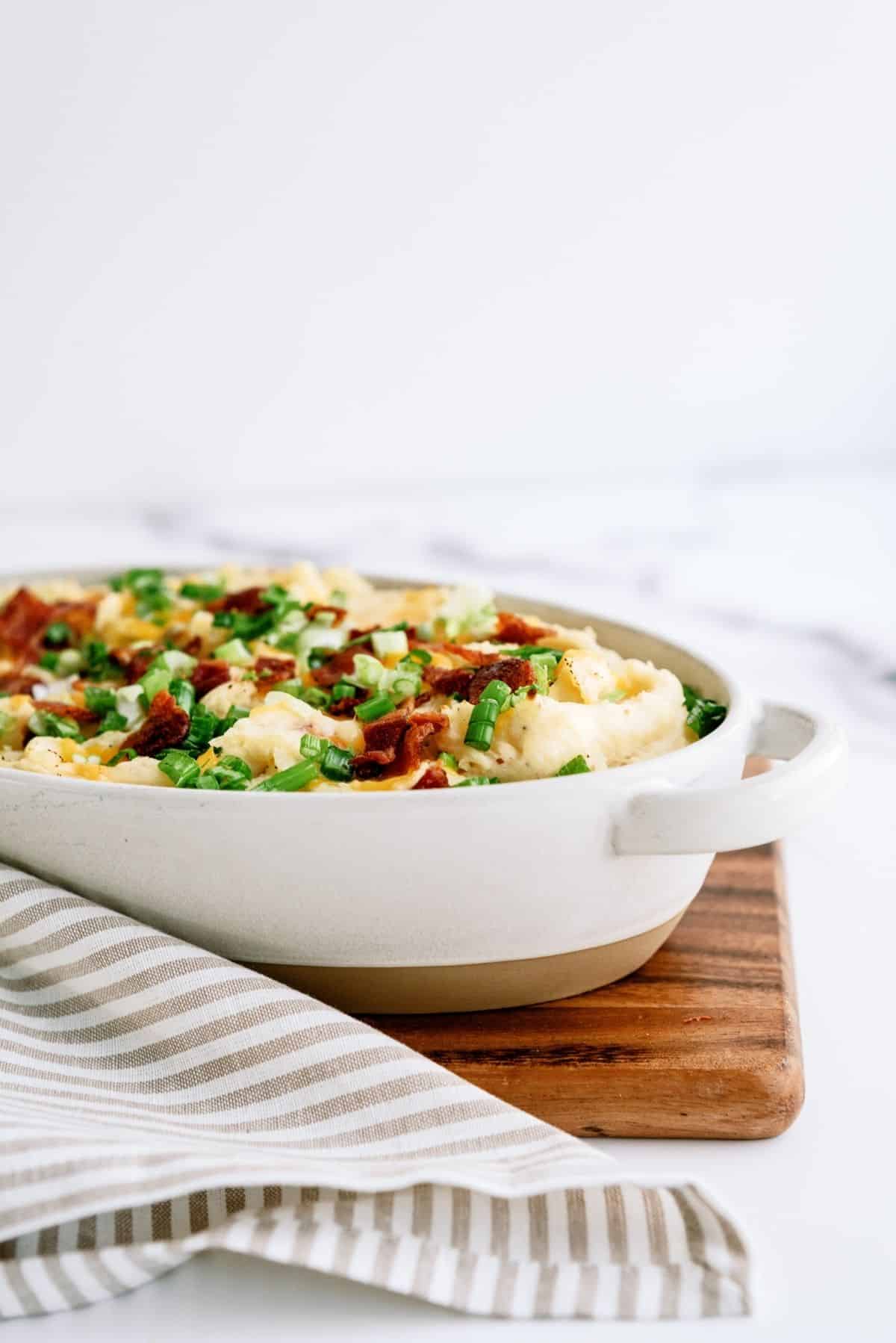 Cheesy Ranch Potatoes in a baking dish on a cutting board