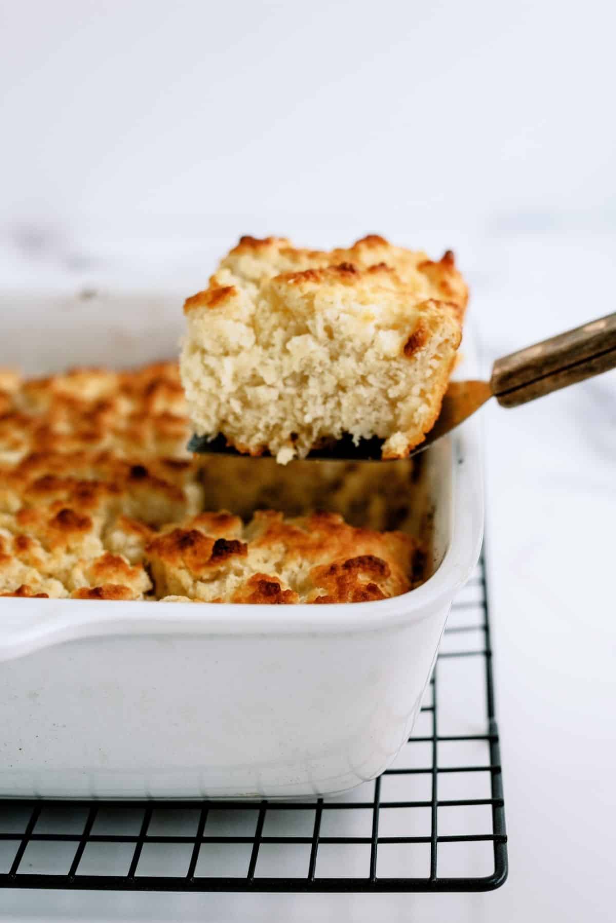 A square of Easy Pan Butter Biscuits being lifted out of the pan