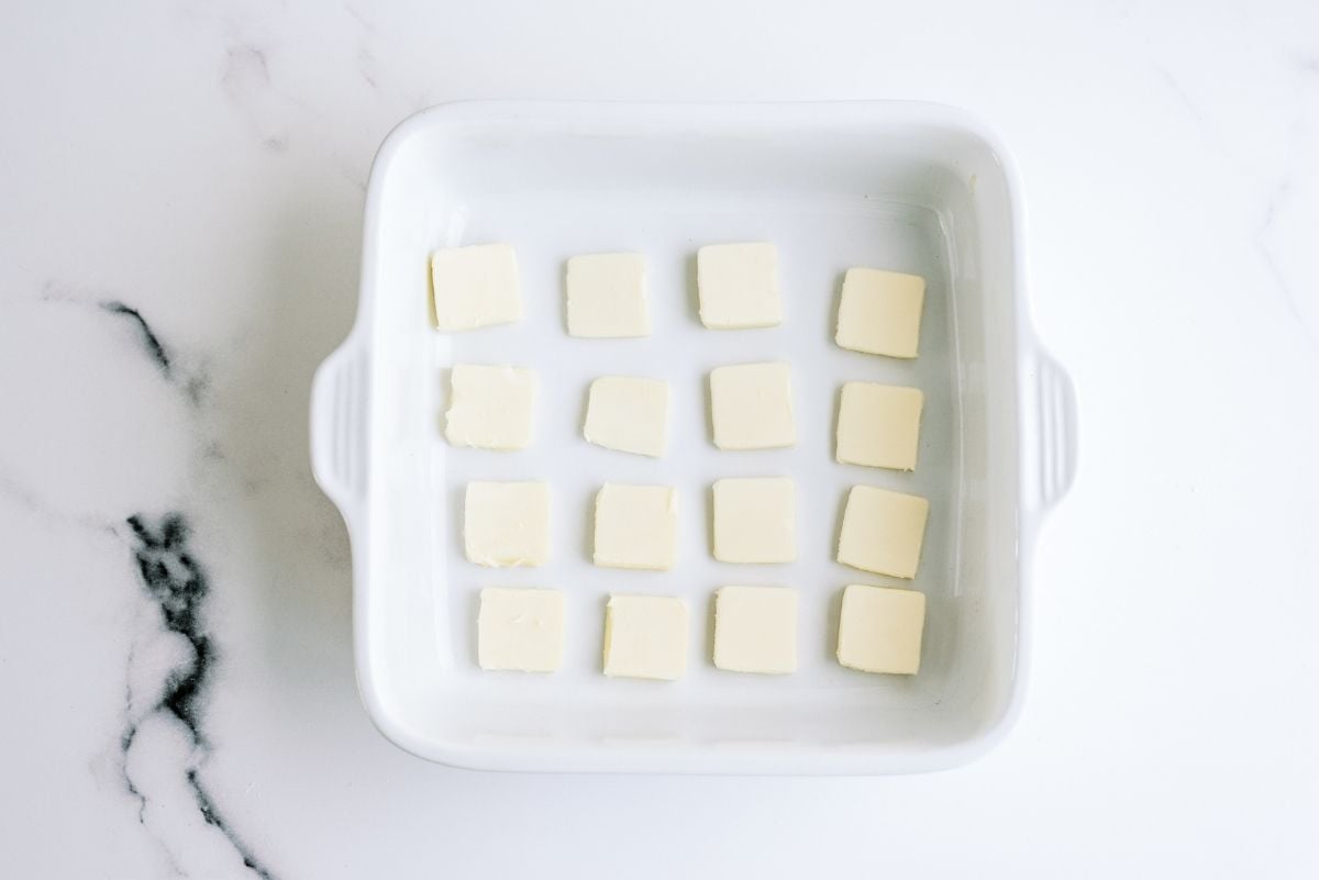 Butter squares laid out in an 8x8 baking dish