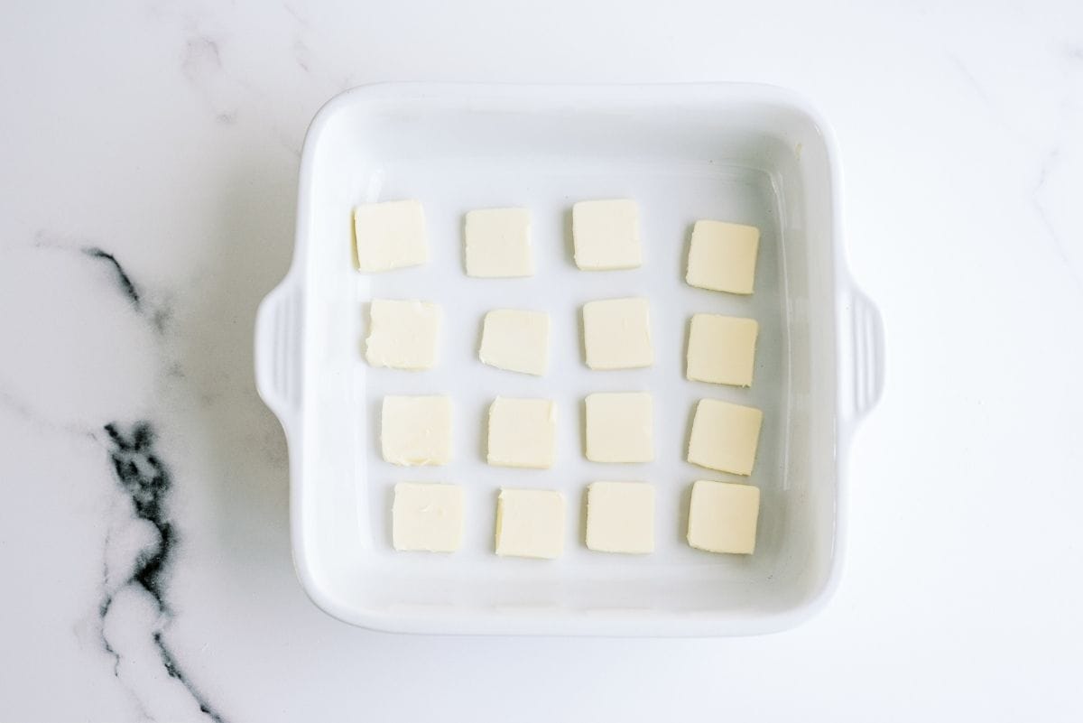 Butter squares laid out in an 8x8 baking dish