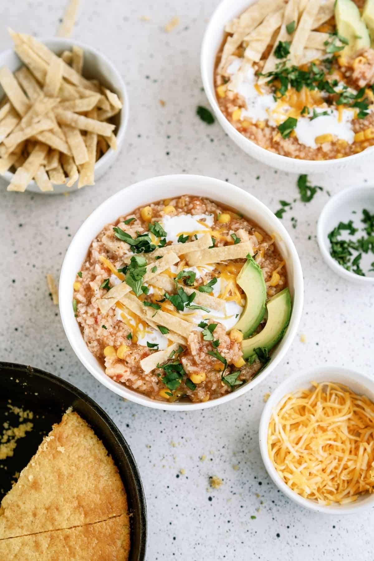 Hearty Chicken Tortilla Soup with tortilla strips and cheese on the side