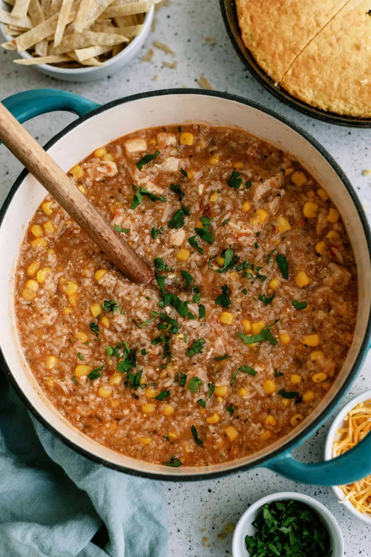 Hearty Chicken Tortilla Soup in a stock pot with a wooden spoon