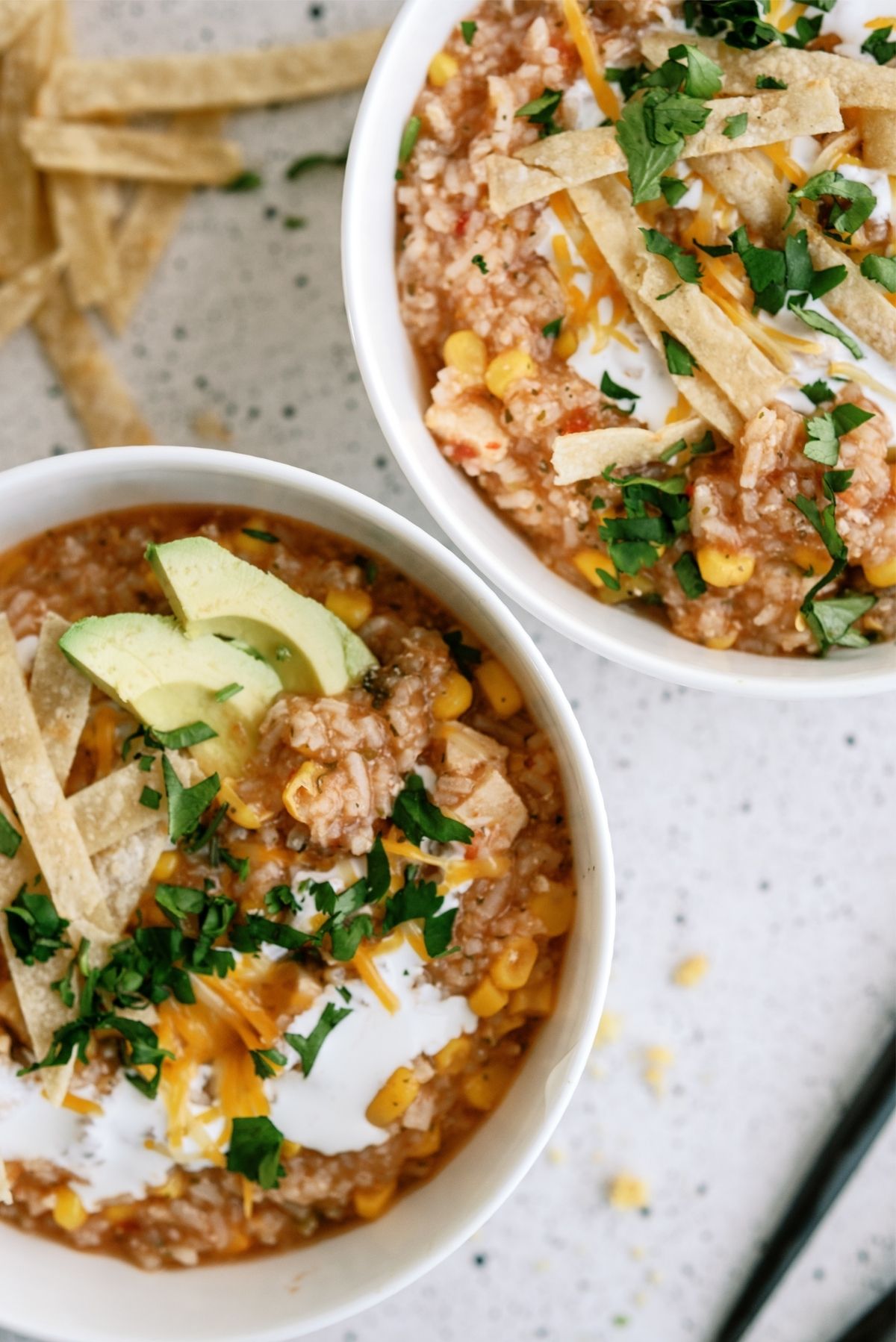 Hearty Chicken Tortilla Soup in two bowls with toppings and tortilla strips