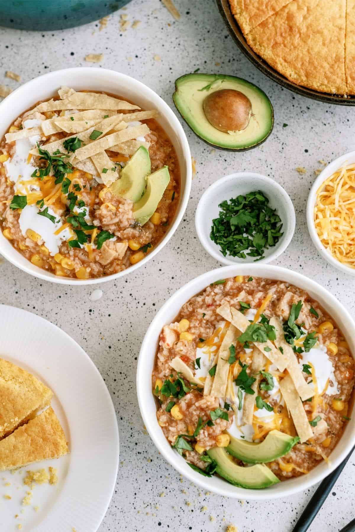 2 bowls of Hearty Chicken Tortilla Soup with toppings