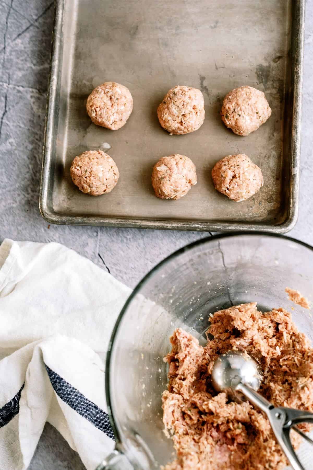 Ground turkey meatballs in 1 1/2 inch balls on a cookie sheet