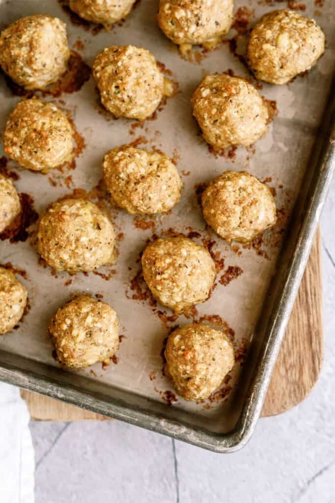 Cooked Turkey meatballs lined up on a baking sheet.