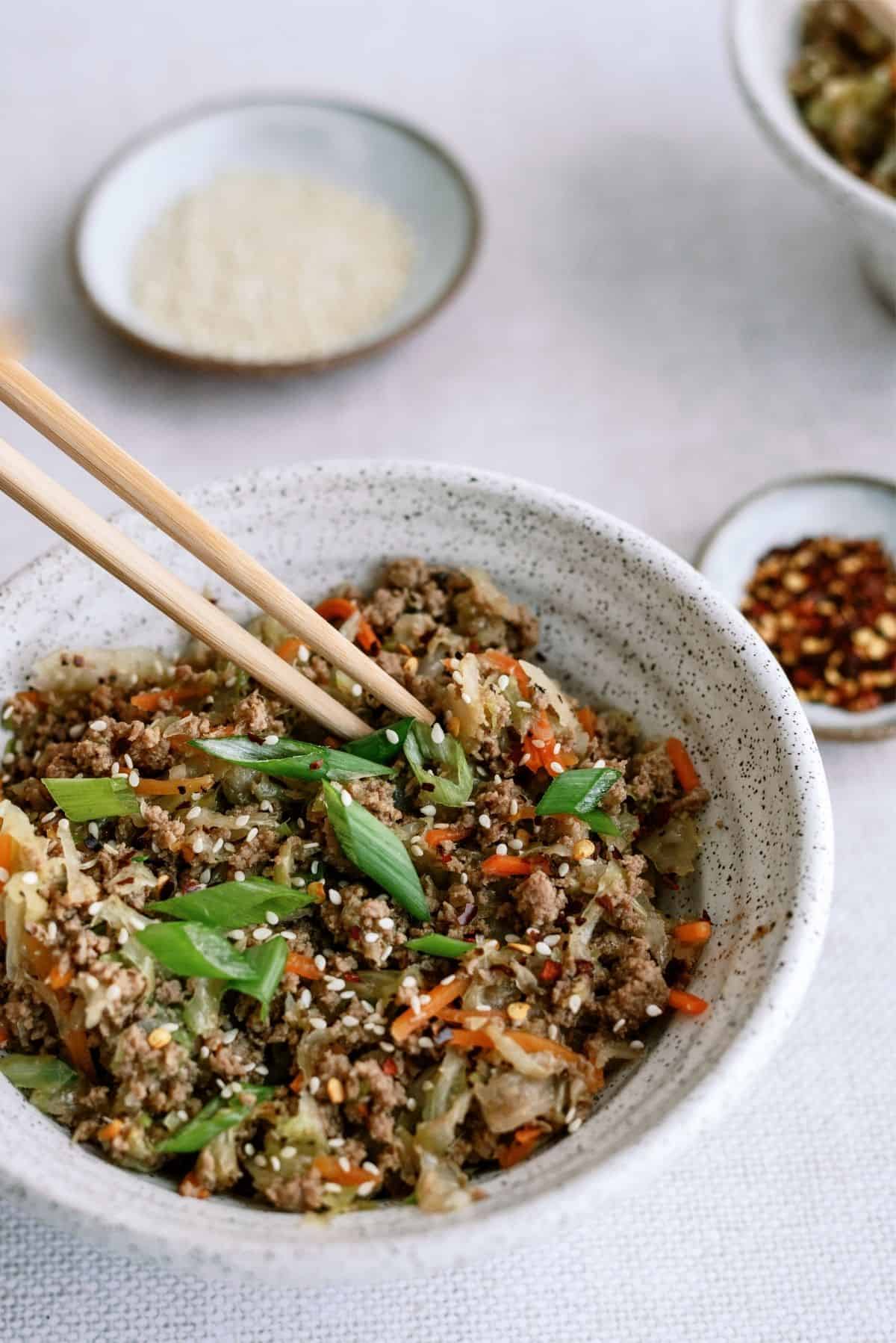 Instant Pot Egg Roll Bowls in a bowl with chopsticks and sauce on the side