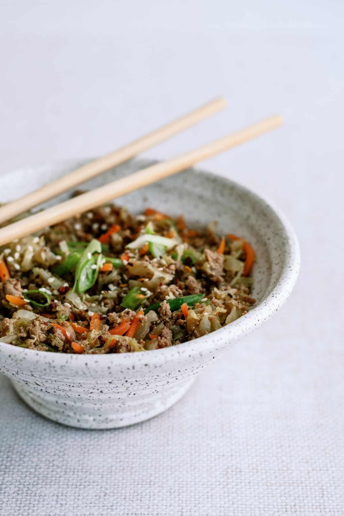 Close up of Instant Pot Egg Roll Bowls in a bowl with chopsticks