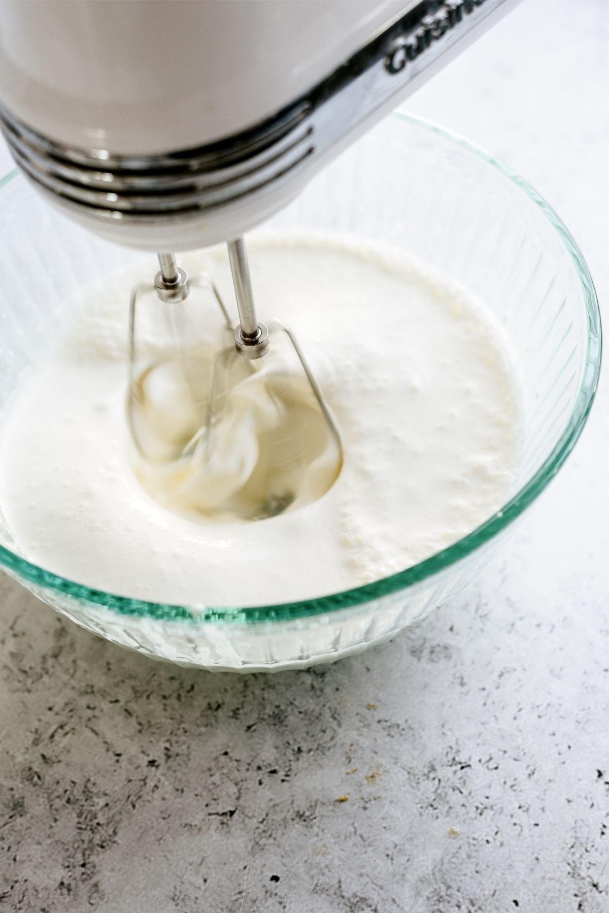 Heavy Cream whipped by a stand mixer in a bowl