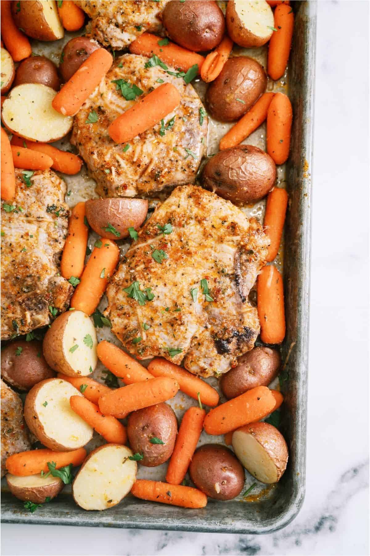 Baked Sheet Pan Italian Pork Chops on a sheet pan with potatoes and carrots.