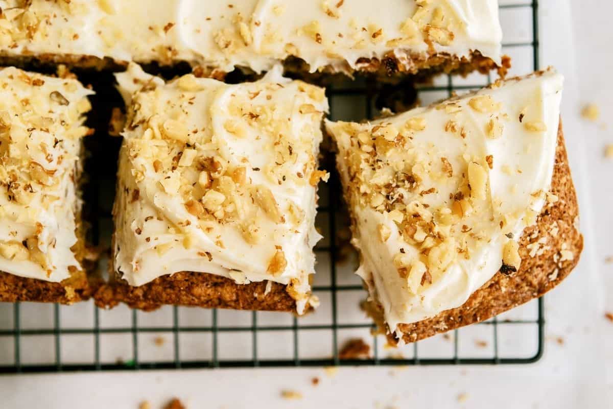 Best Carrot Cake frosted and sliced into squares on a cooling rack