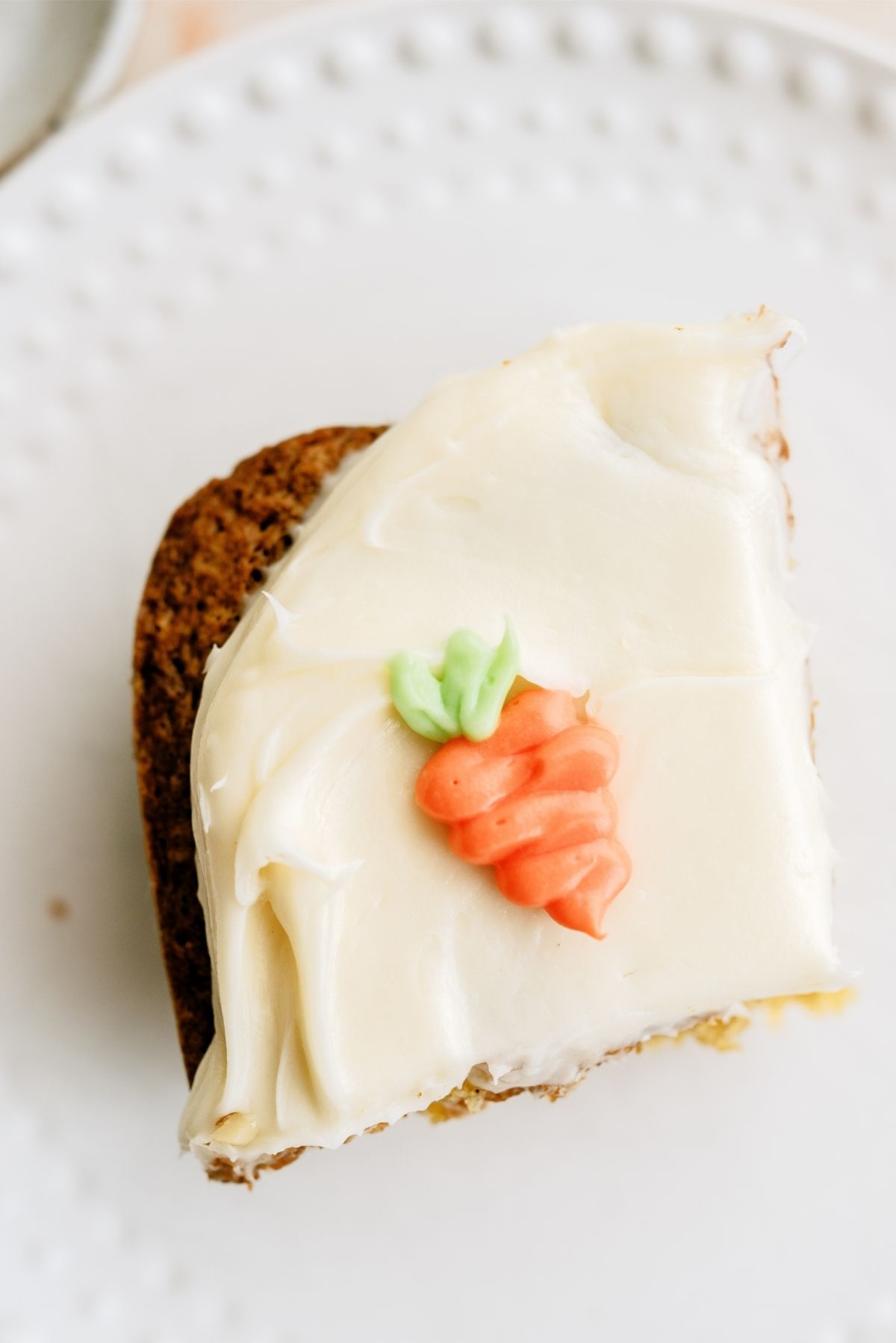 A slice of the Best Carrot Cake on a plate, frosted