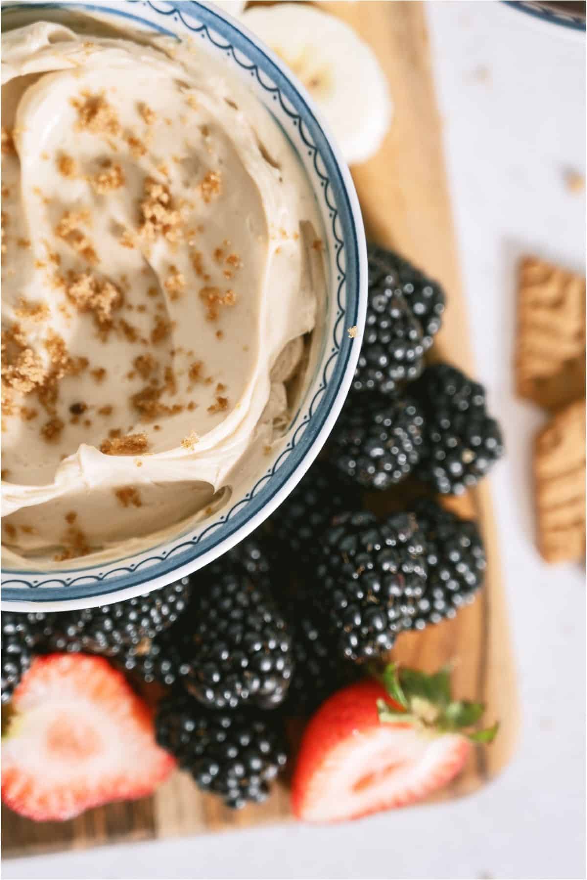 Close up of a bowl of Brown Sugar Cream Cheese Fruit Dip next to blackberries.