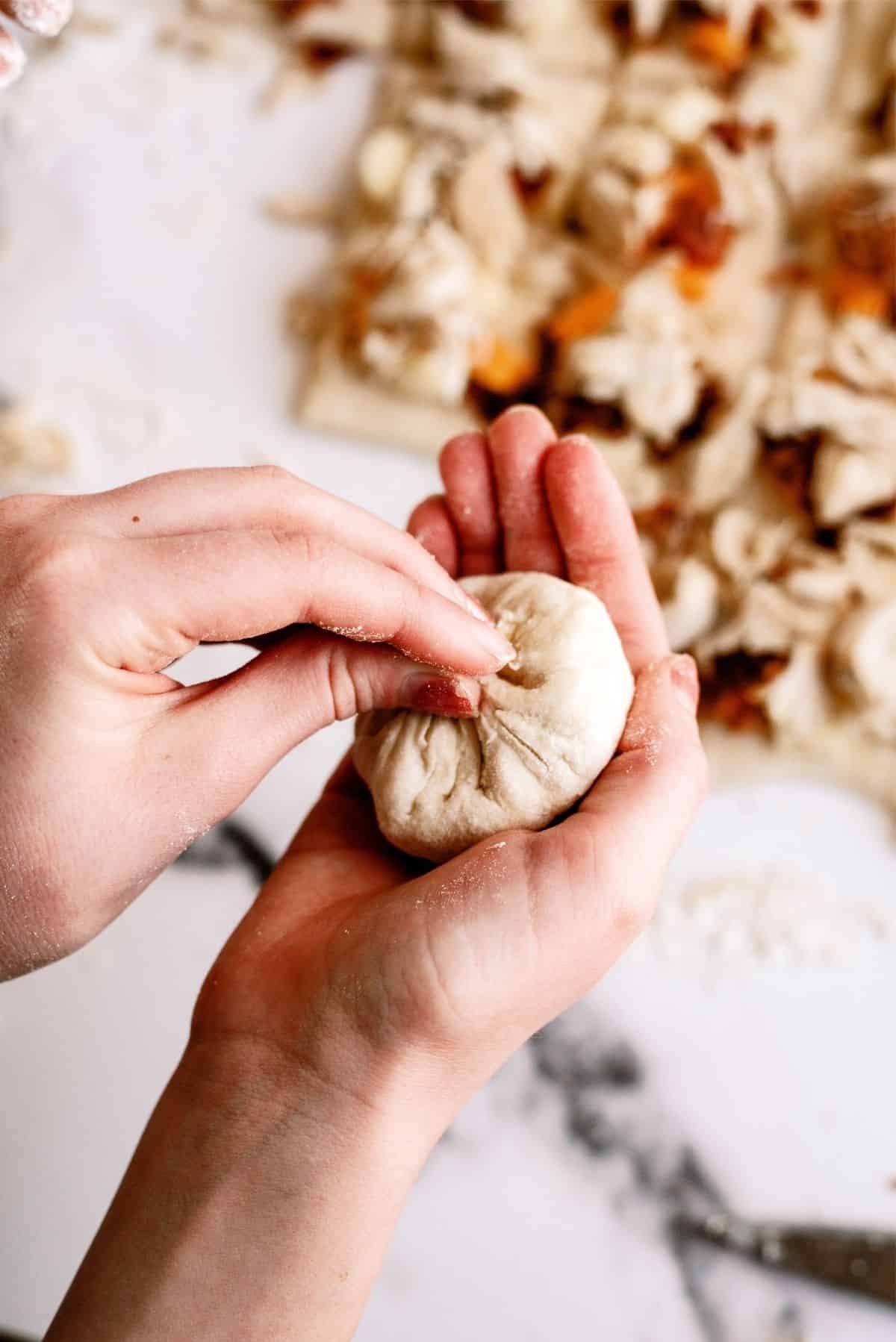 Pinching the corners of the dough squares together