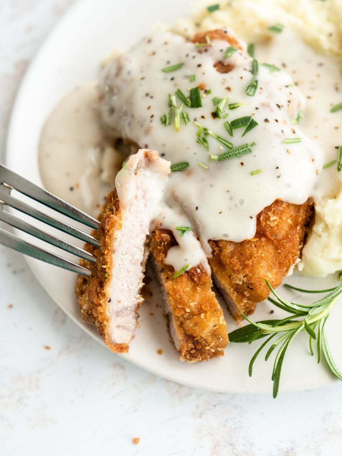 Chicken Fried Pork Chops on a plate with country gravy