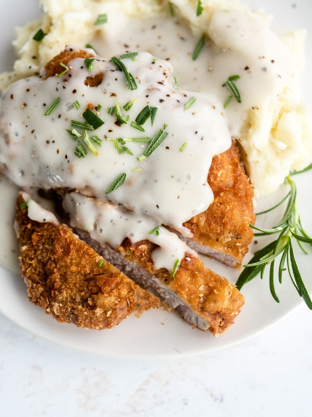 Chicken Fried Pork Chops on a plate sliced with country gravy