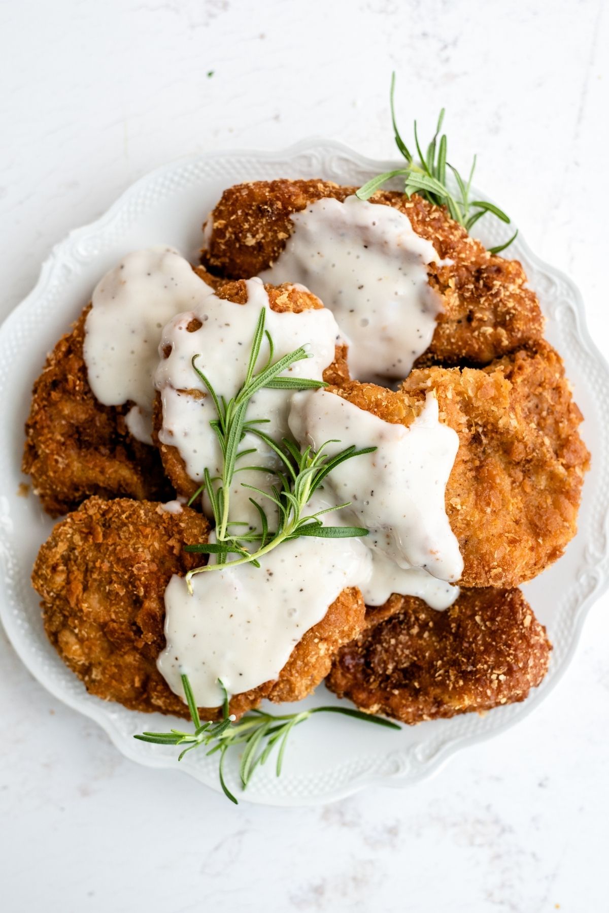 A plate full of Chicken Fried Pork Chops with country grave on top