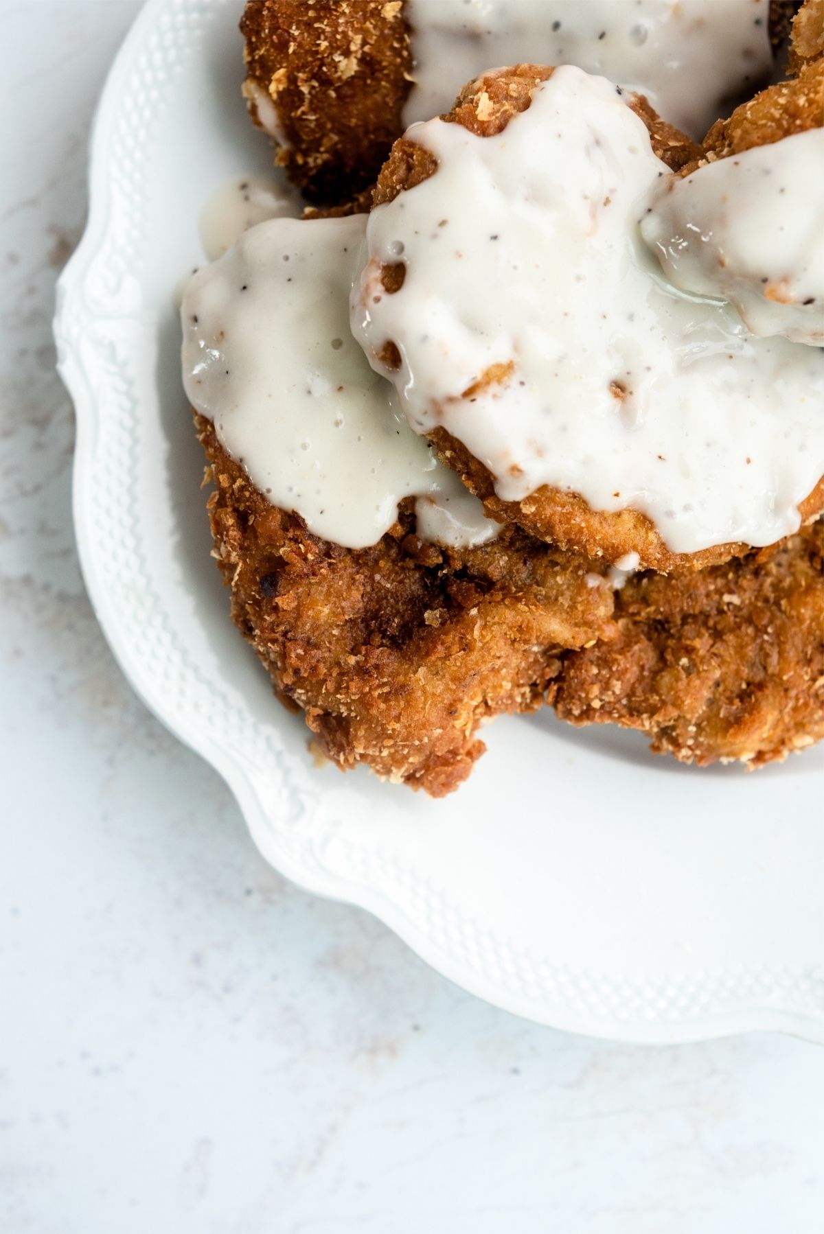 Chicken Fried Pork Chops on a plate with country gravy on top