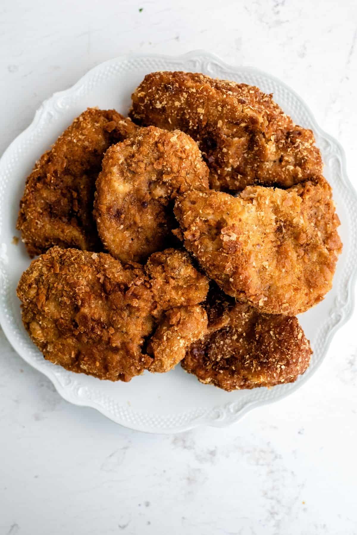 A plate with a paper towel full of Chicken Fried Pork Chops