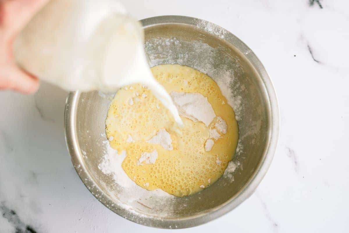 Pouring milk into bowl to mix with pudding mix