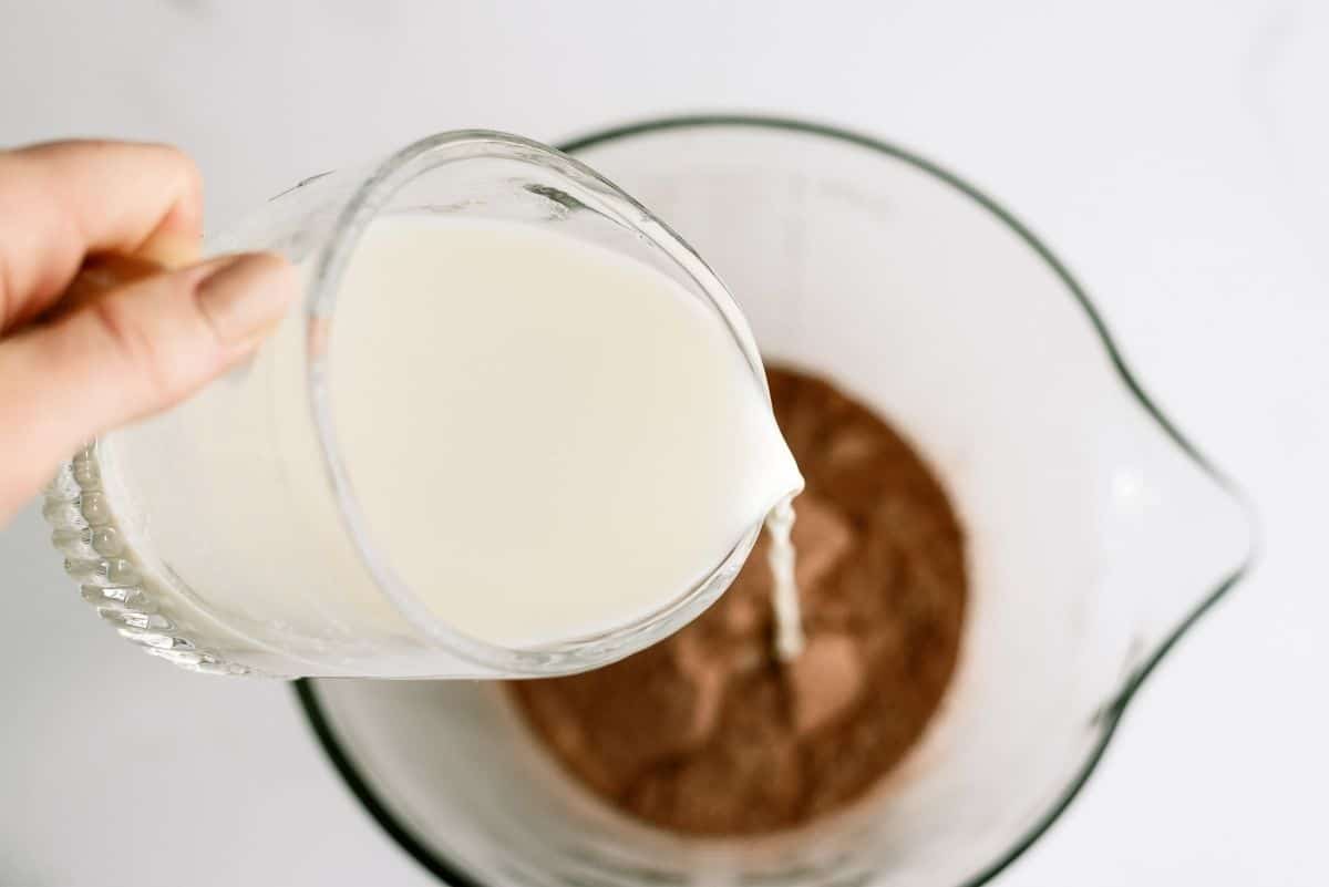 Pouring milk into bowl with dry pudding mixture