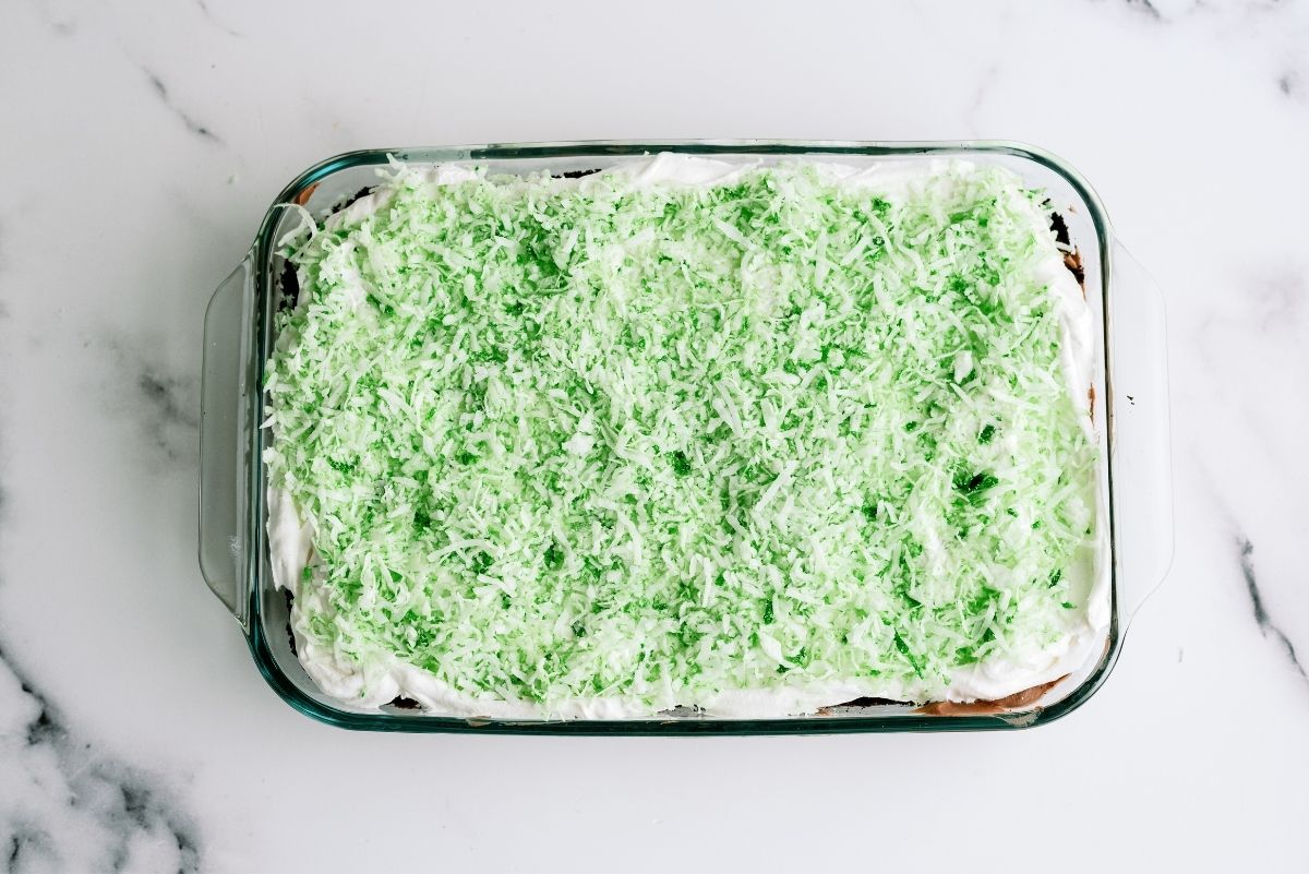 Green shredded coconut spread over top layer of cake