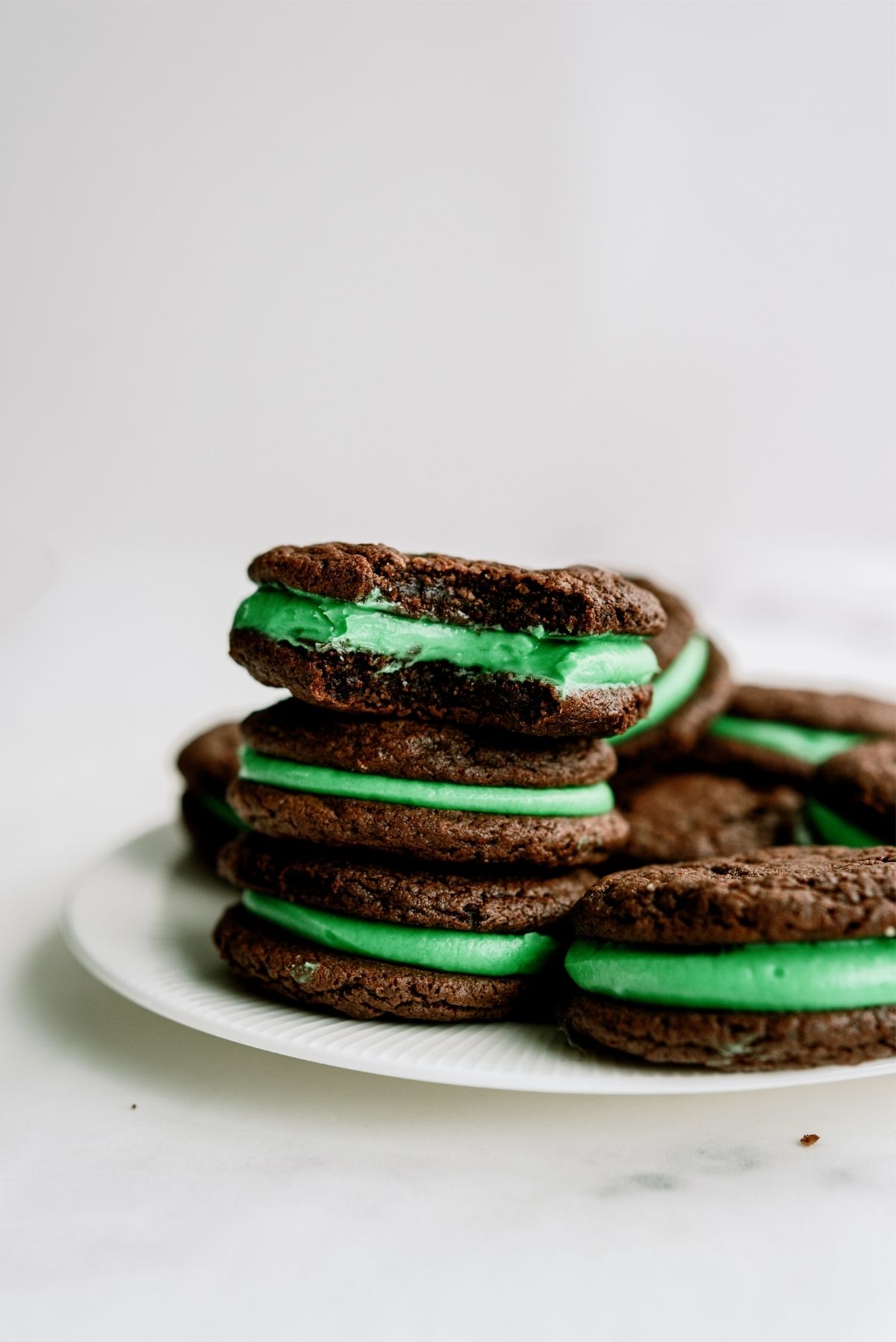 Grasshopper Sandwich Cookies on a plate with a bite taken out of one