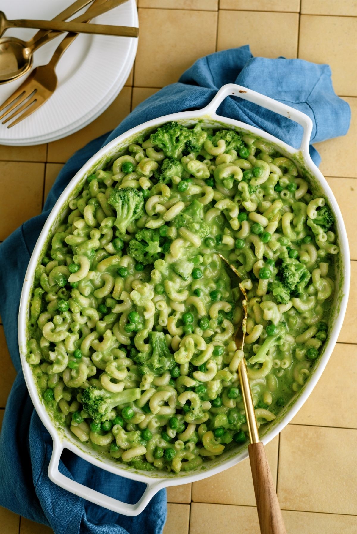 Green Mac and Cheese without Food Coloring in a baking dish with a serving spoon