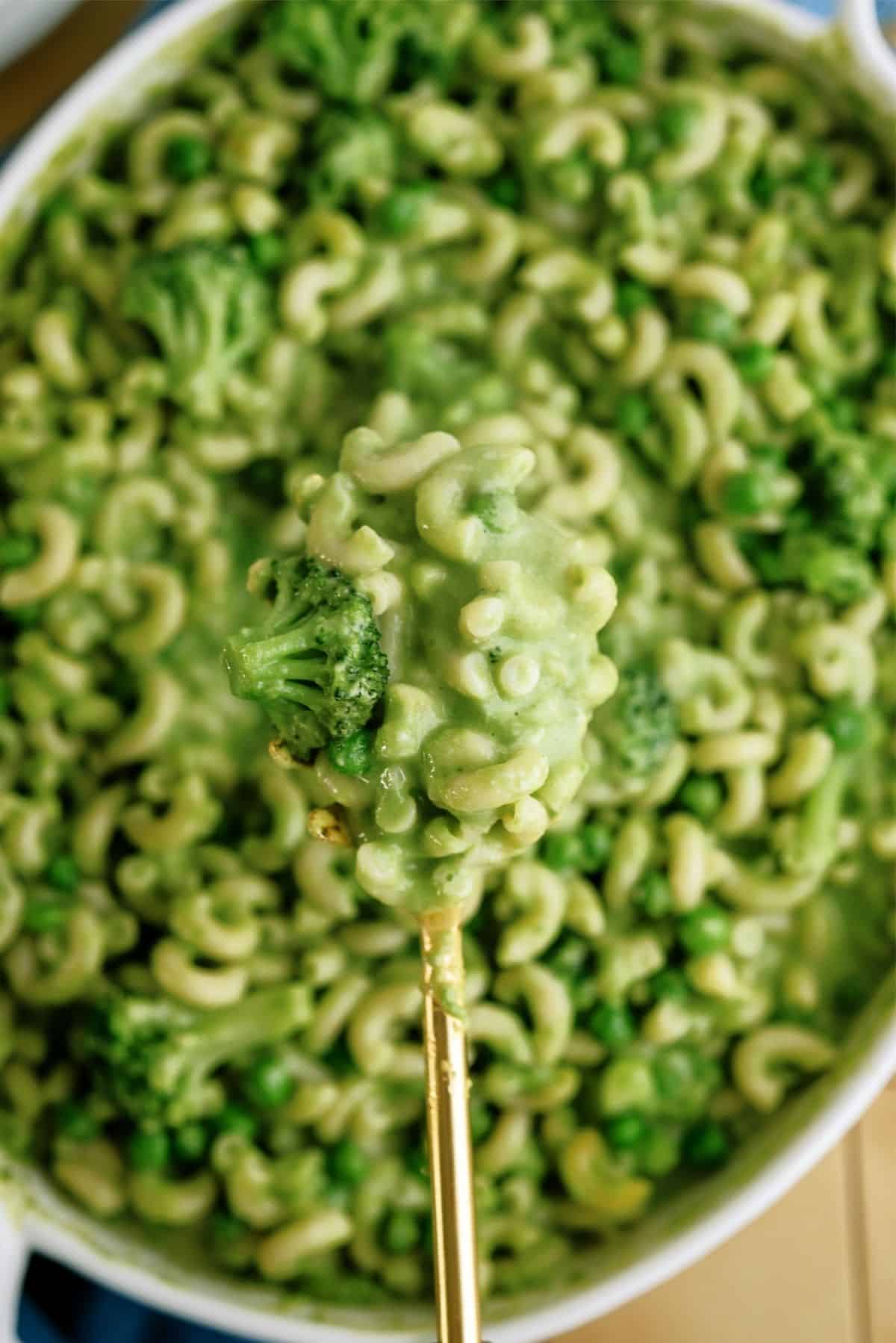 A spoonful of Green Mac and Cheese without Food Coloring in a casserole dish