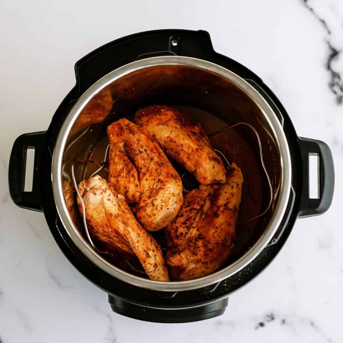 Browned chicken on trivet in Instant Pot