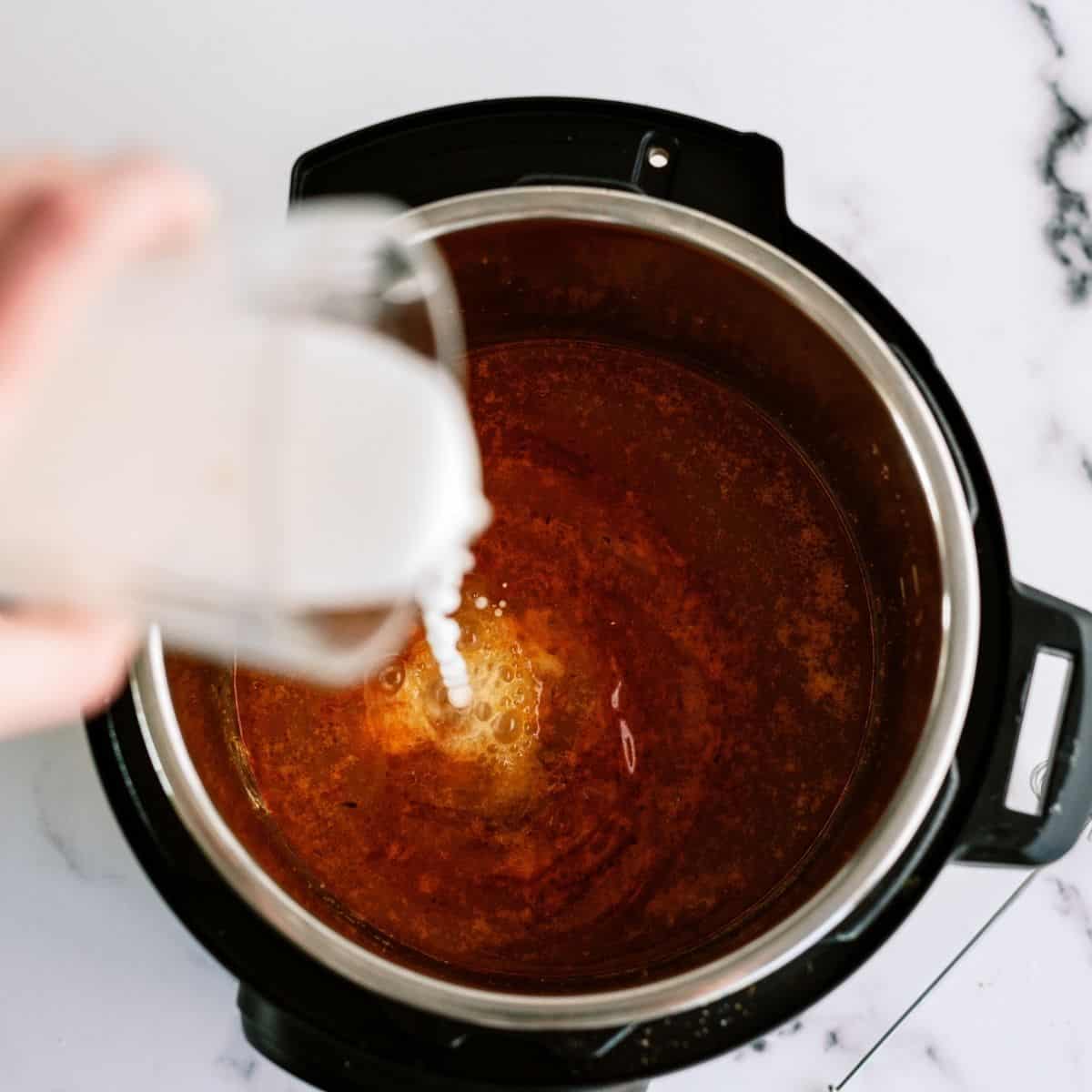 Pouring cornstarch mixture into Instant Pot