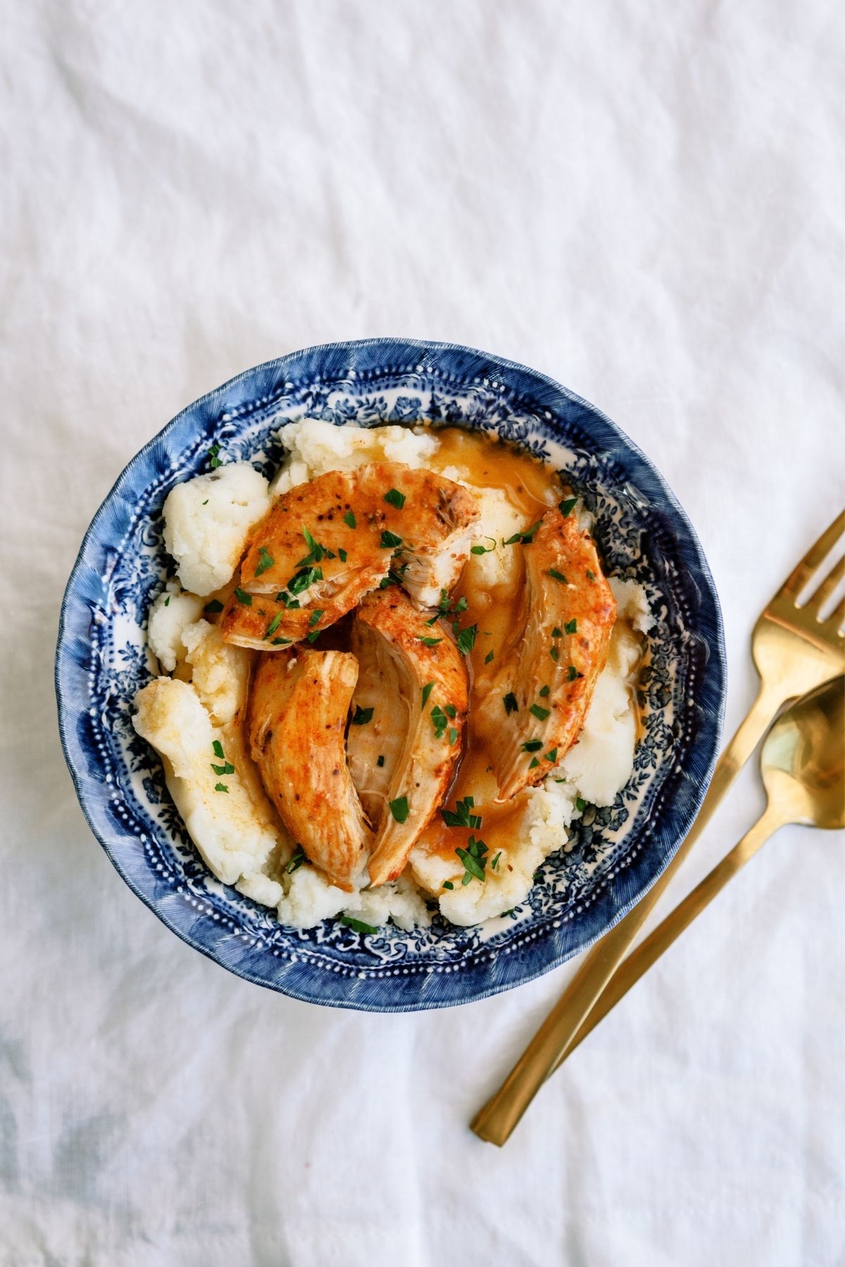 Instant Pot Chicken and Gravy served over mashed potatoes in a bowl