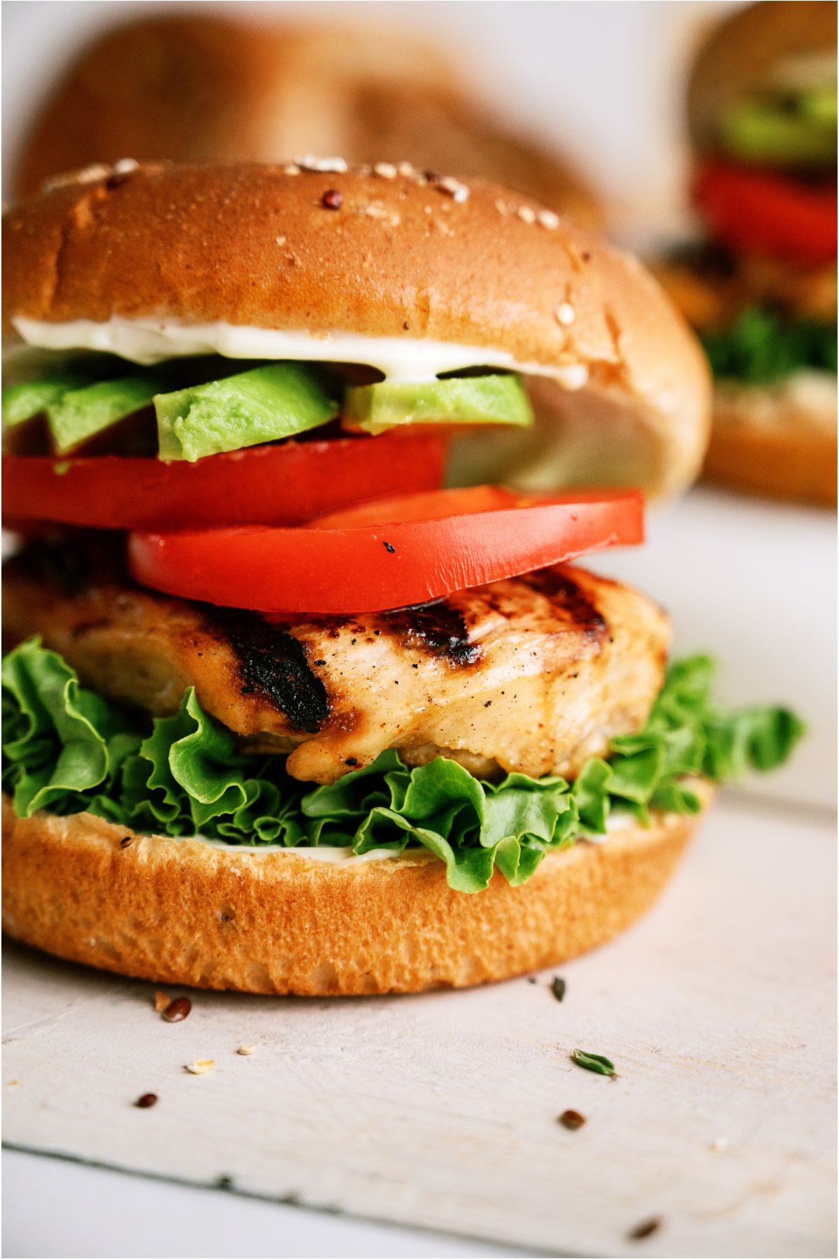 Close up of Marinated Grilled Chicken Sandwich with toppings.