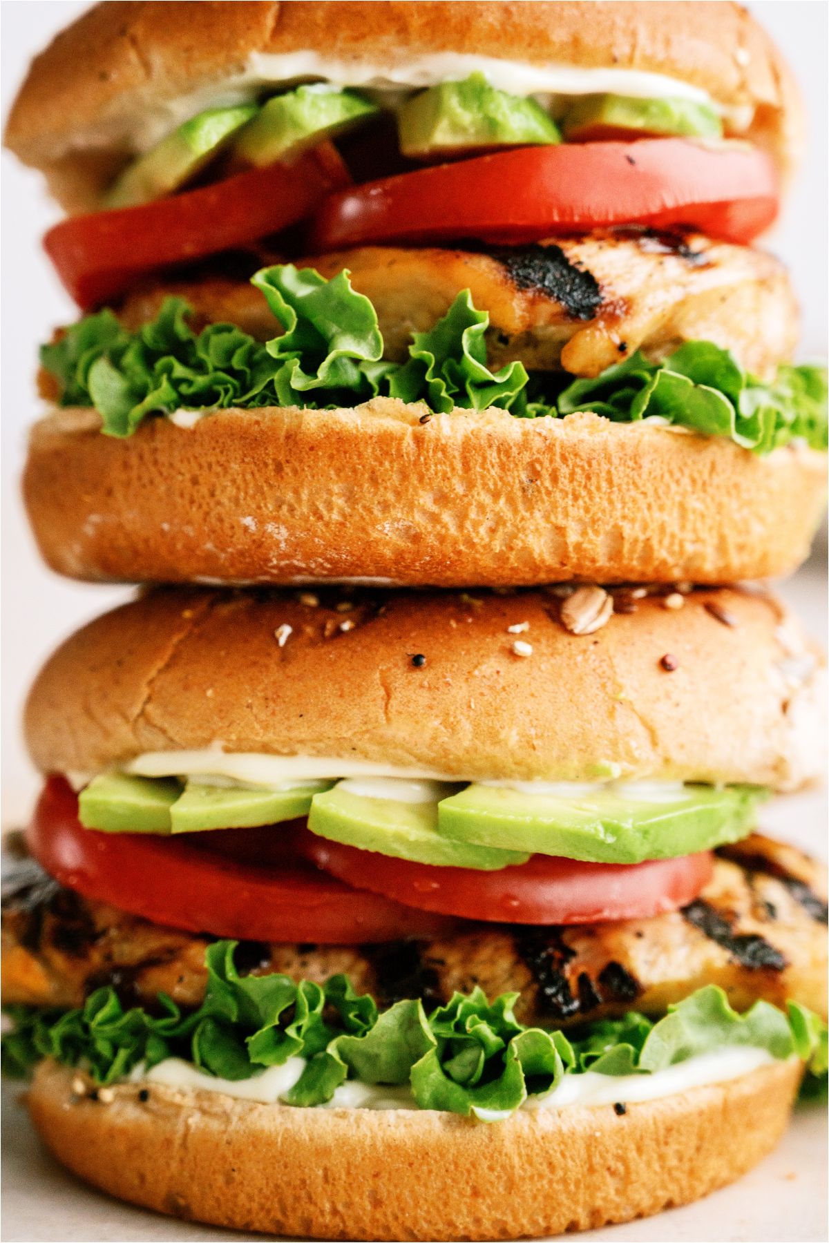 Close up of 2 Marinated Grilled Chicken Sandwich stacked on top of each other.