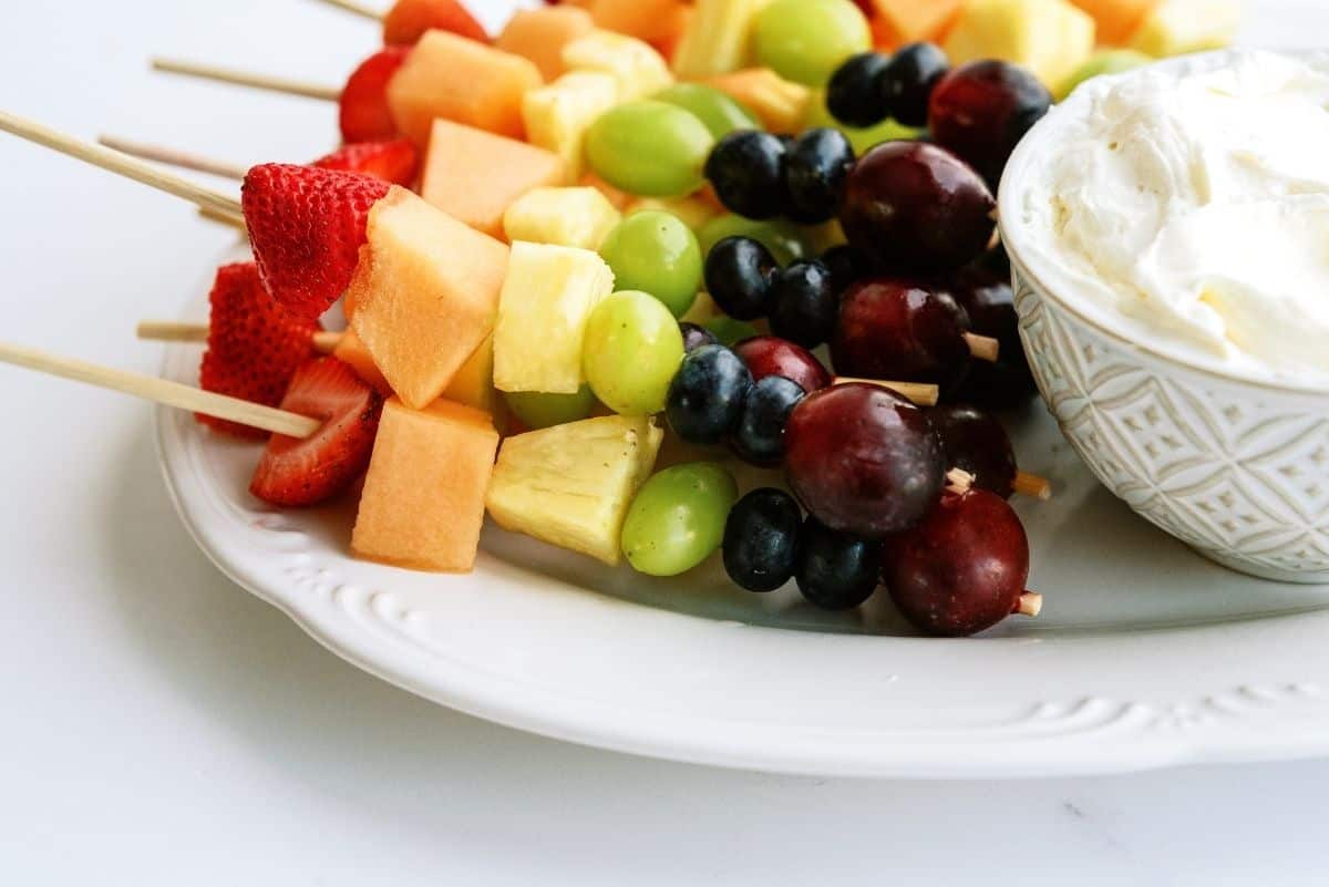 Rainbow Fruit Kabobs with Fluffy Marshmallow Dip on a plate