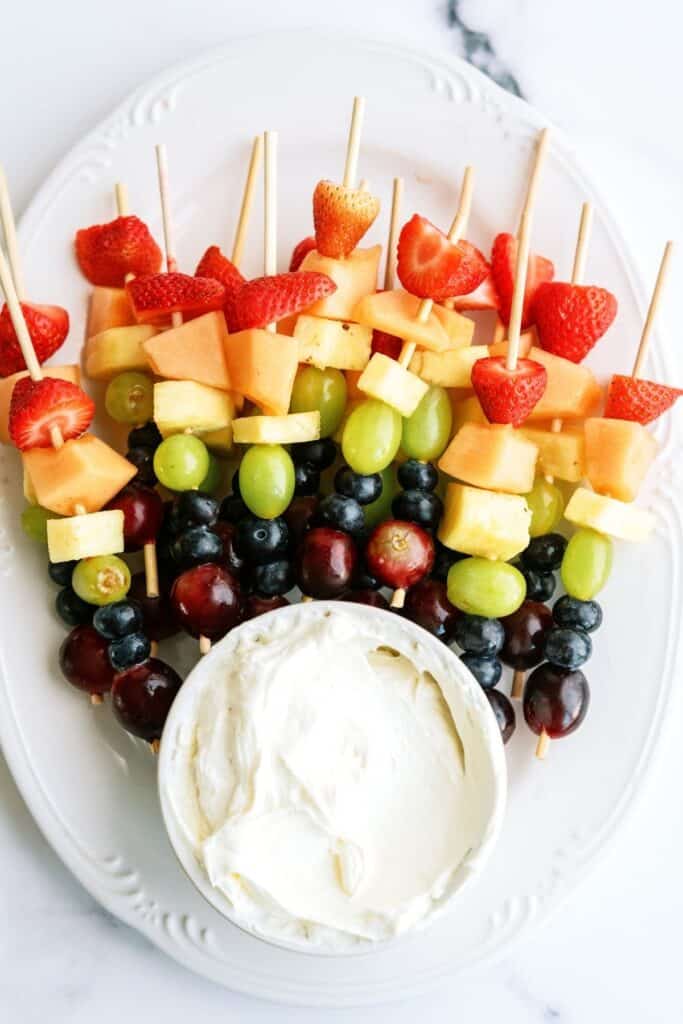 A platter of Rainbow Fruit Kabobs with Fluffy Marshmallow Dip.