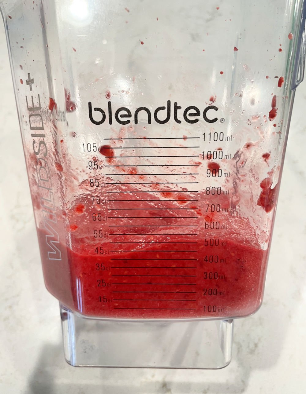 Raspberries, lemon juice and sugar blended inside of a blender.