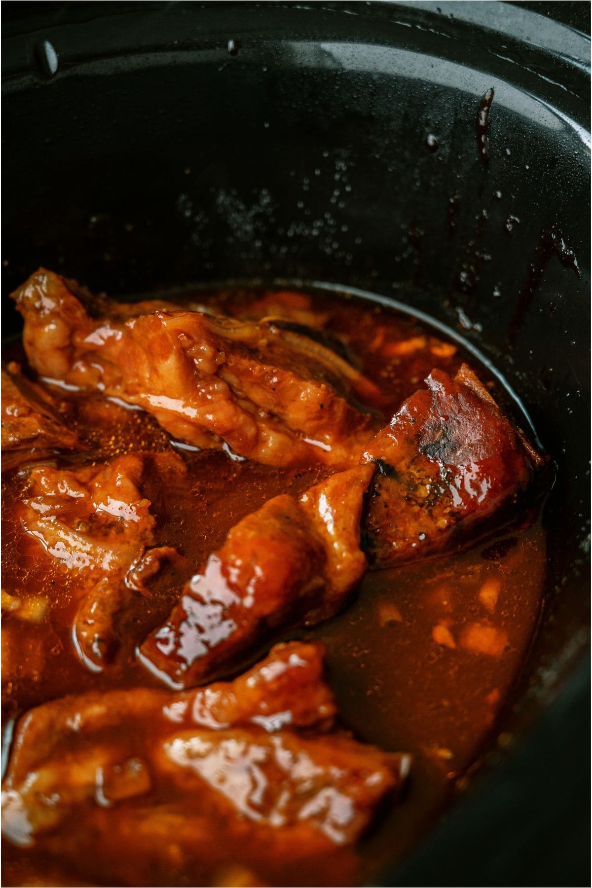 BBQ Slow Cooker Country Style Ribs in the slow cooker covered in sauce.