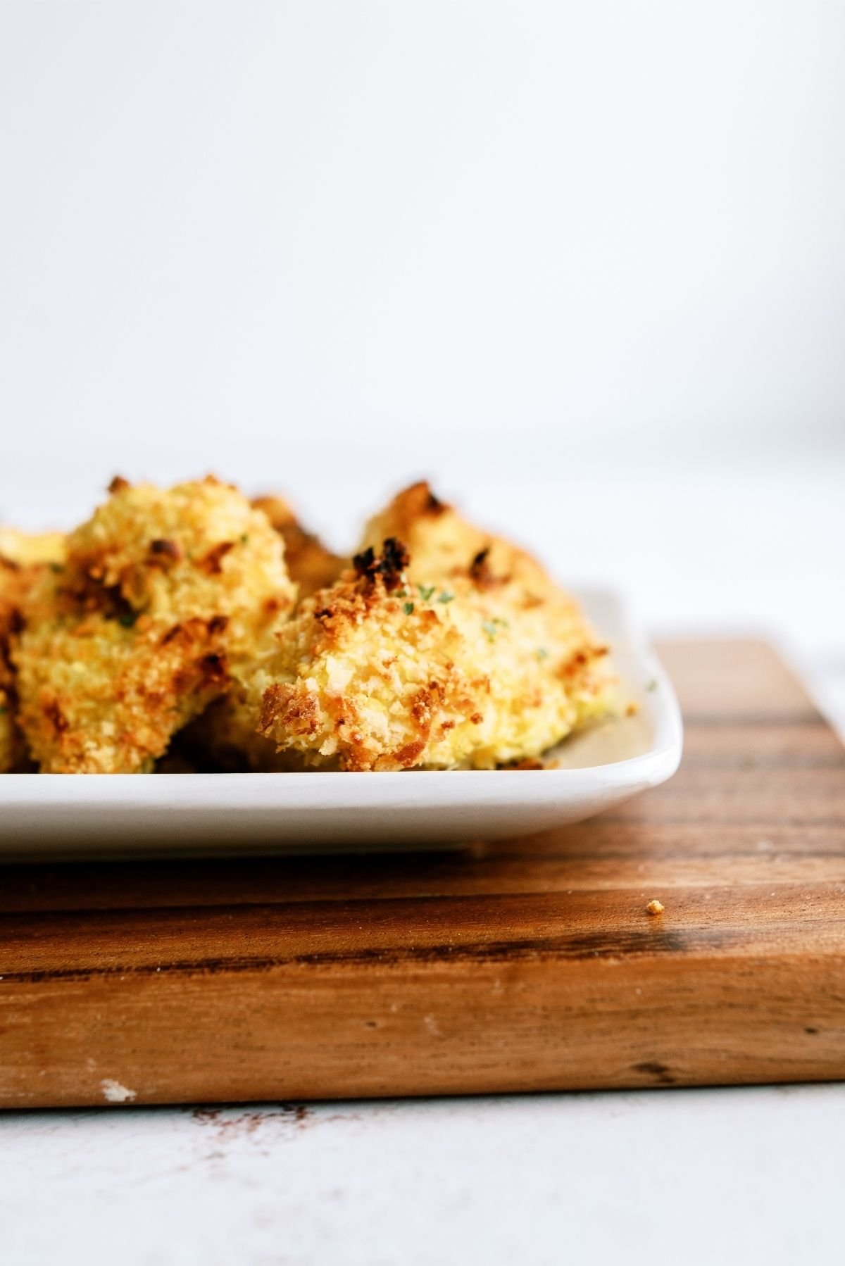 Side view of Baked Crispy Coconut Chicken Tenders on a serving plate
