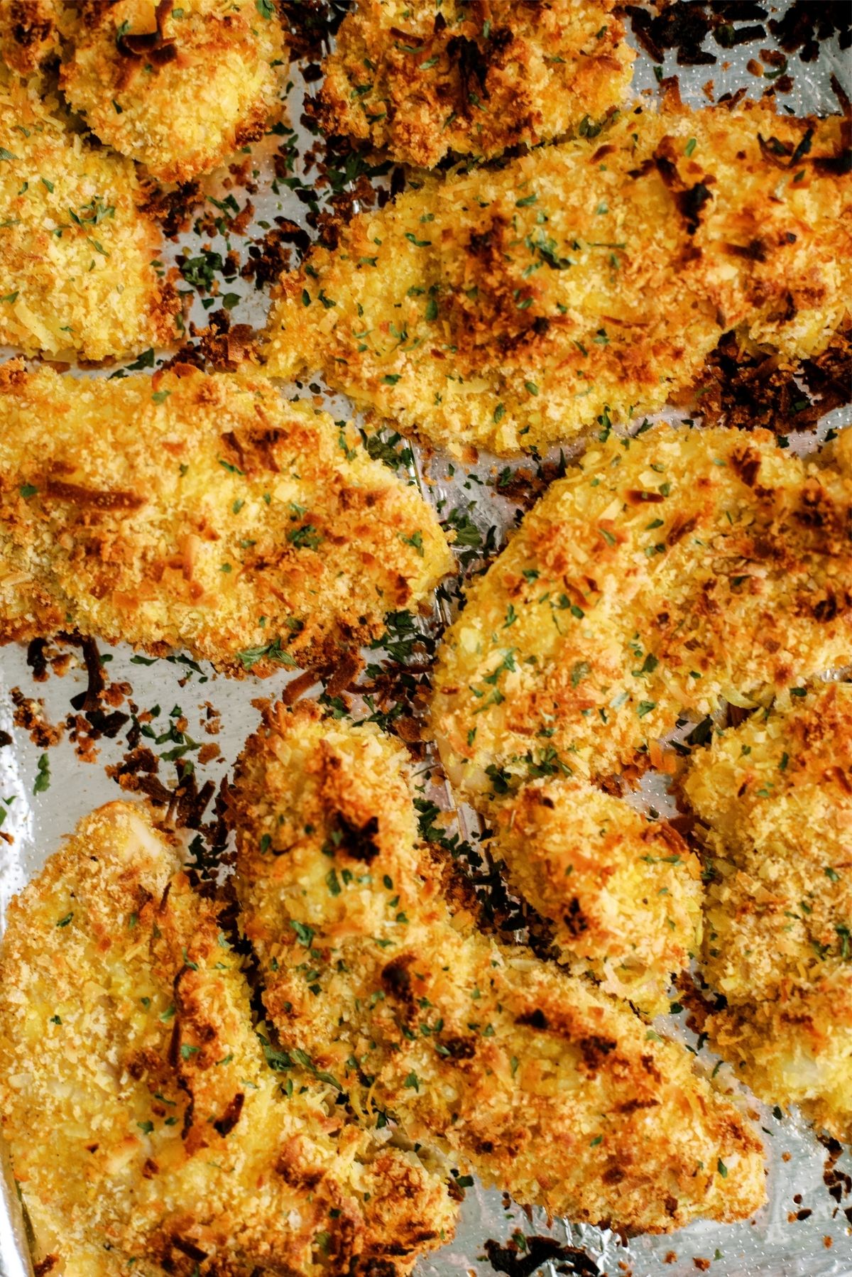 Close up of Baked Crispy Coconut Chicken Tenders on sheet pan