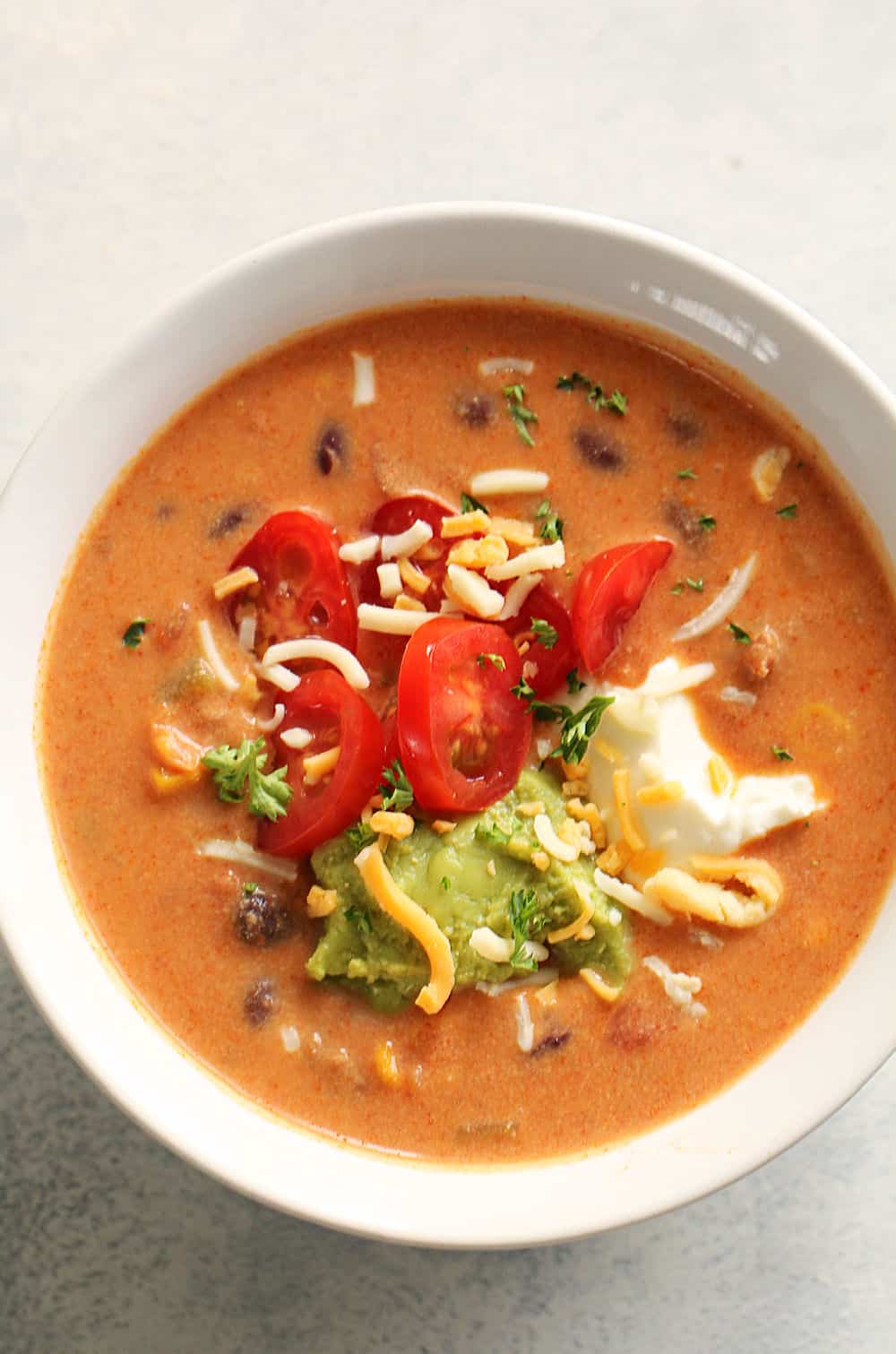 A bowl of 20 Minute Cheesy Beef Taco Soup with toppings