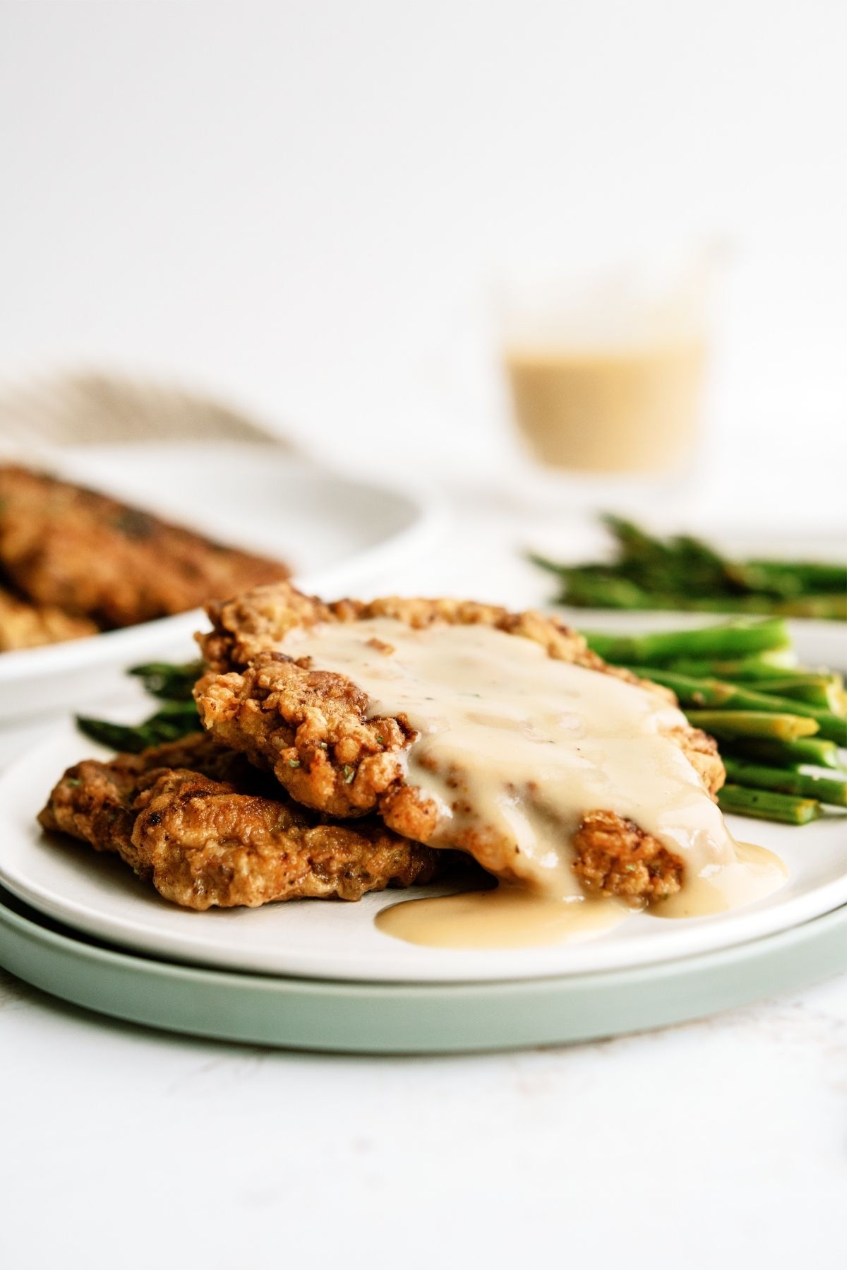 Chicken Fried Steak with Gravy on a plate served with asparagus