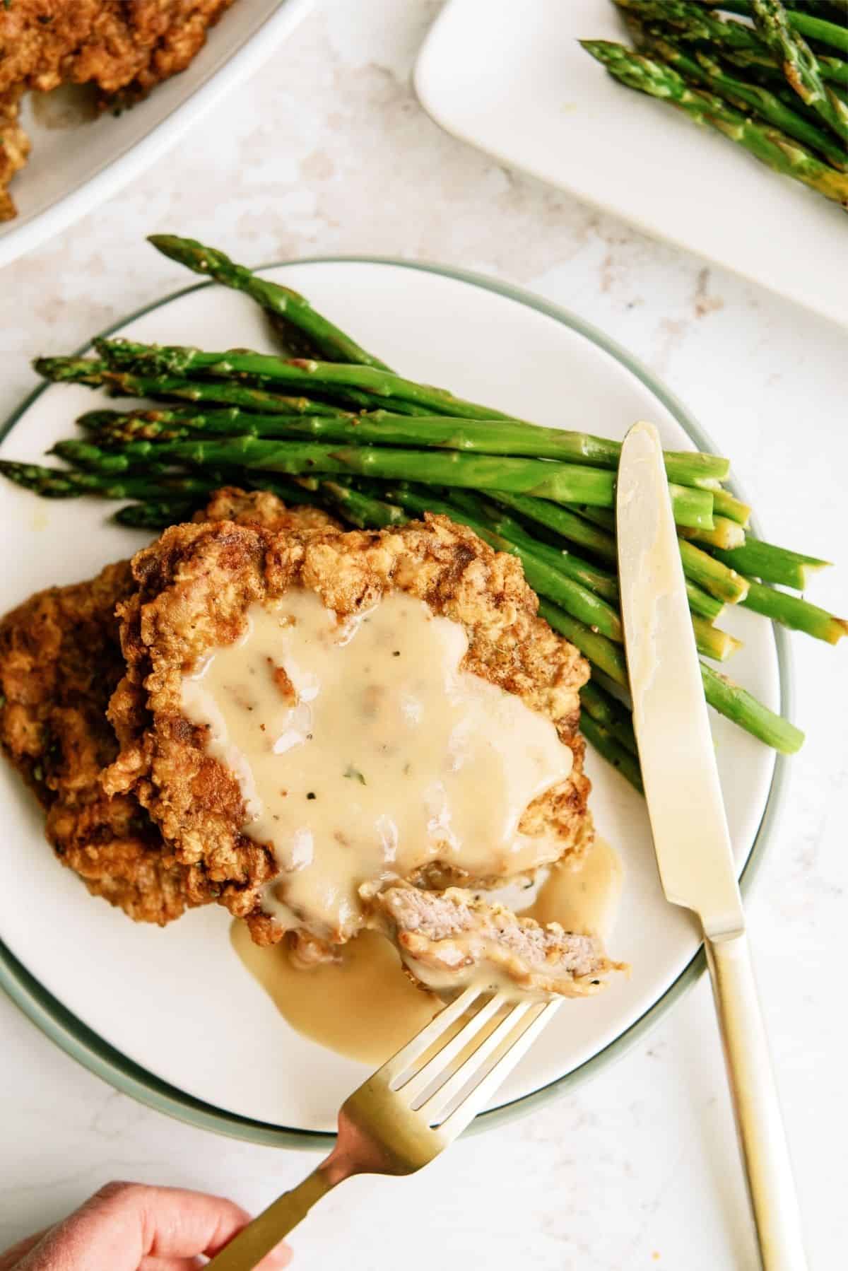 Chicken Fried Steak with Gravy on a plate with a fork and knife