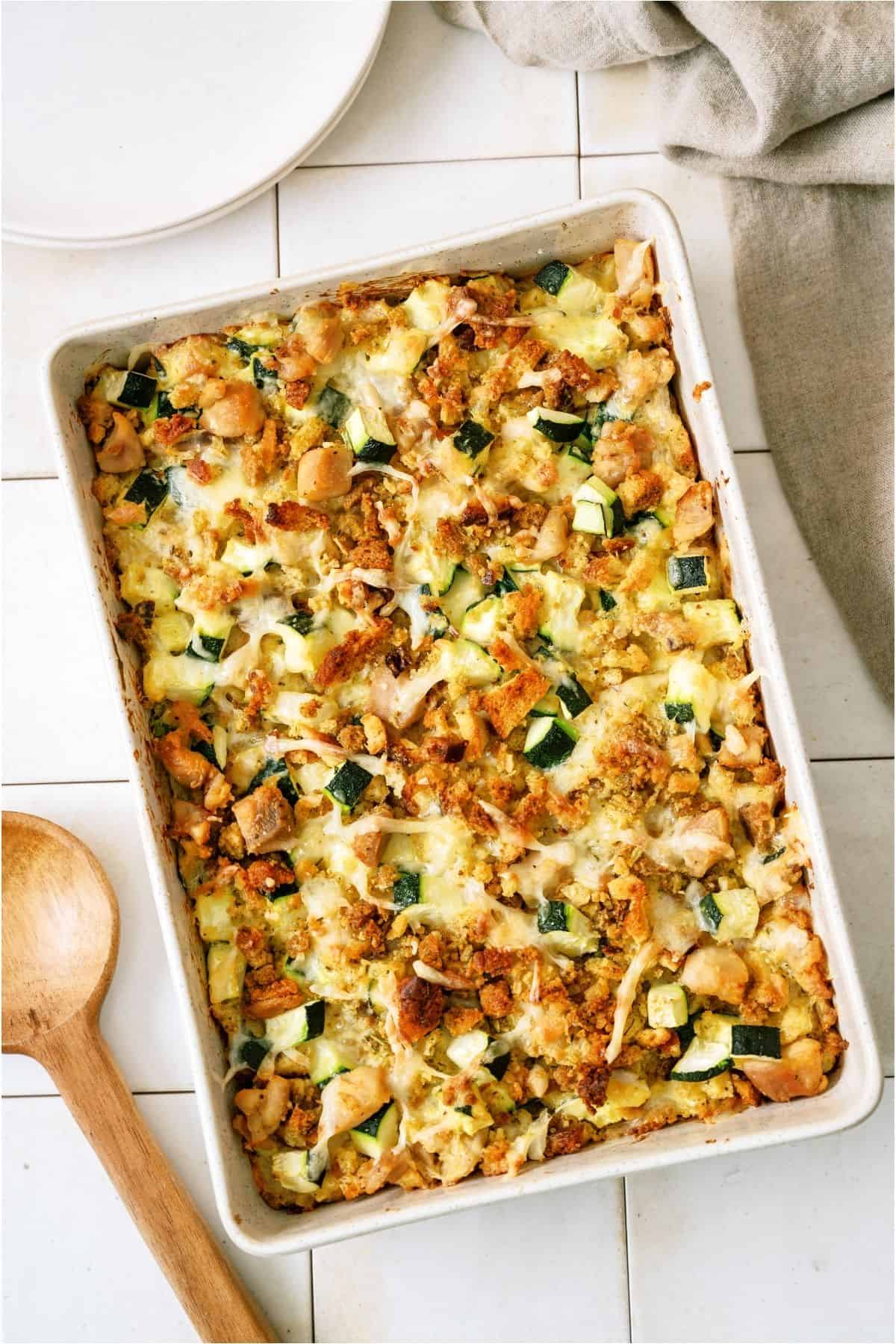 Chicken Zucchini Casserole in casserole dish with a wooden spon next to it.