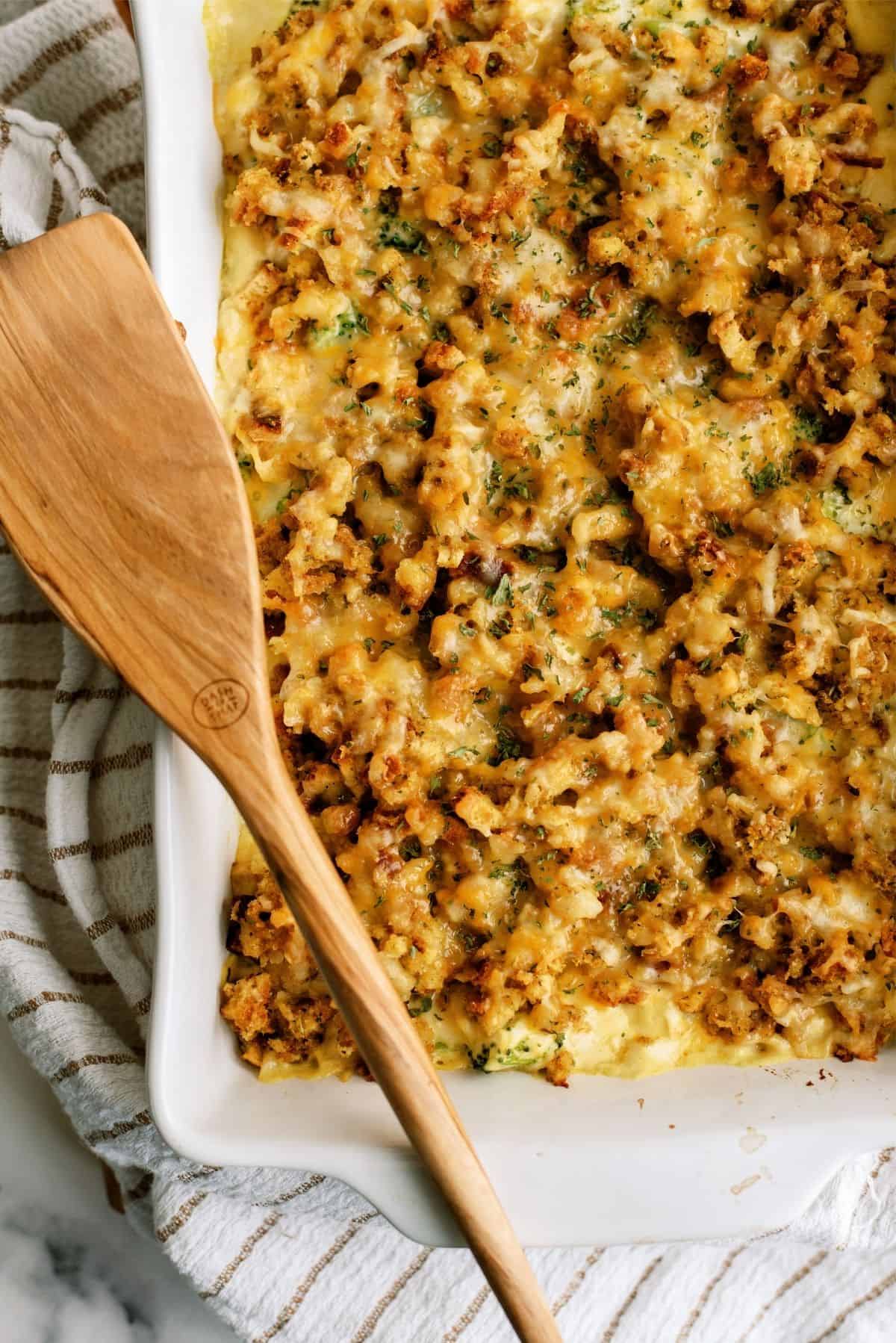 Top view of Chicken and Broccoli Stuffing Casserole with a wooden spoon