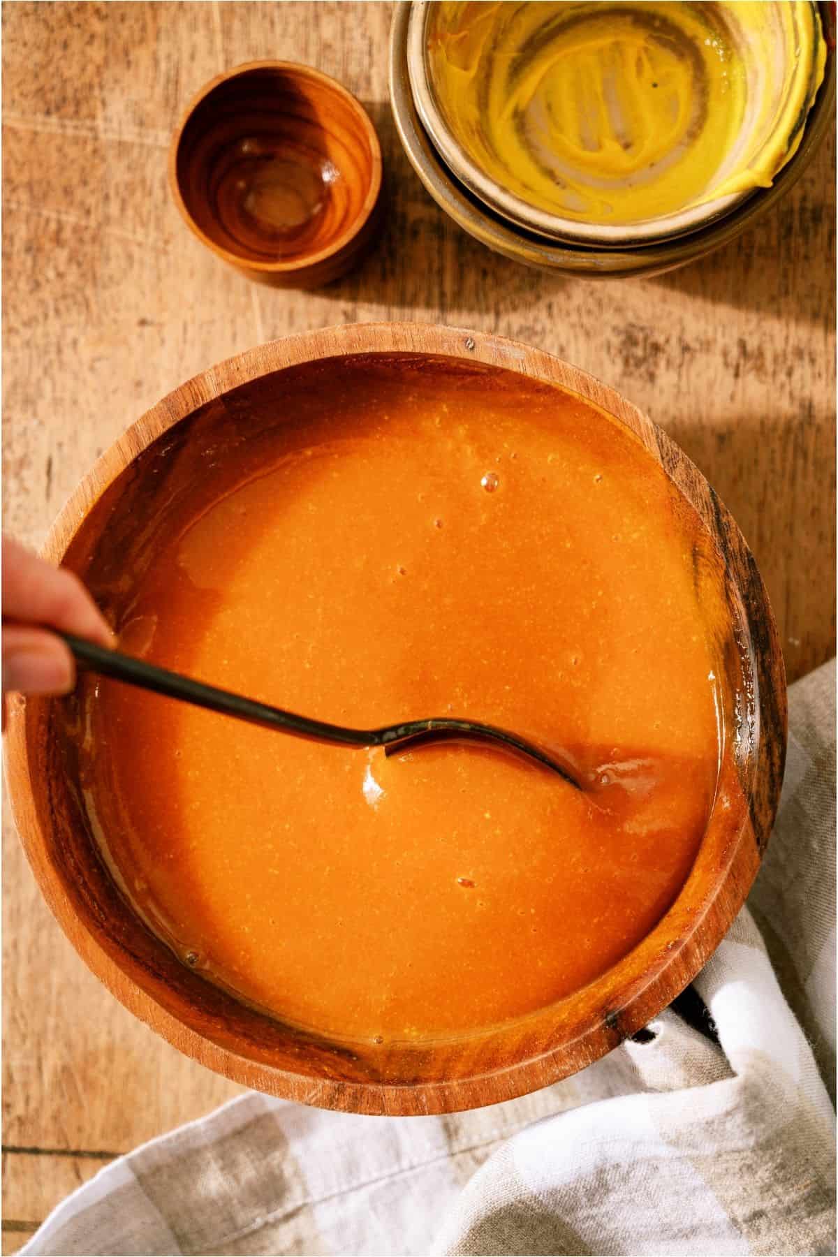 Homemade BBQ sauce in a bowl with a spoon.