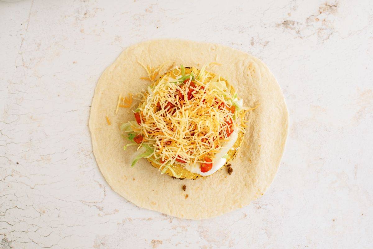 toppings on top of tostada shell inside flour tortilla